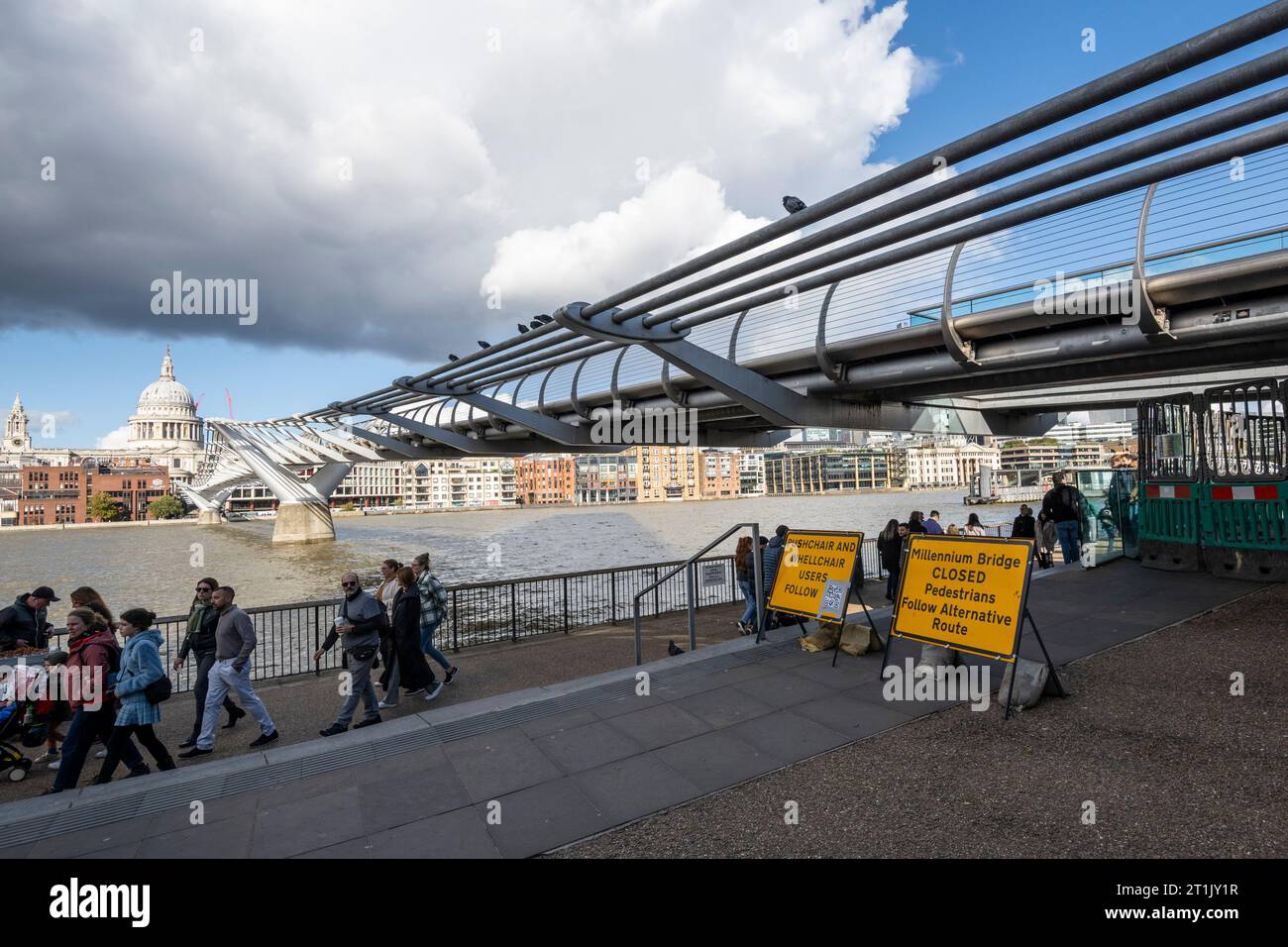 London, UK.  14 October 2023.  Members of the public pass signage informing them that the Millennium Bridge has closed for maintenance.  City Bridge Foundation, a charity that looks after London's major Thames crossings, says that a layer of membrane has started to degrade and needs replacing.  Repairs will take three weeks.  Credit: Stephen Chung / Alamy Live News Stock Photo
