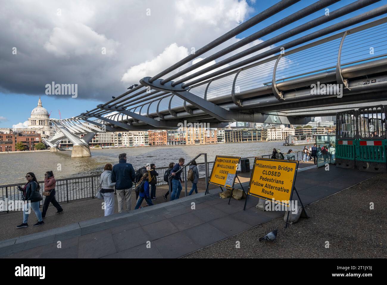 London, UK.  14 October 2023.  Members of the public pass signage informing them that the Millennium Bridge has closed for maintenance.  City Bridge Foundation, a charity that looks after London's major Thames crossings, says that a layer of membrane has started to degrade and needs replacing.  Repairs will take three weeks.  Credit: Stephen Chung / Alamy Live News Stock Photo