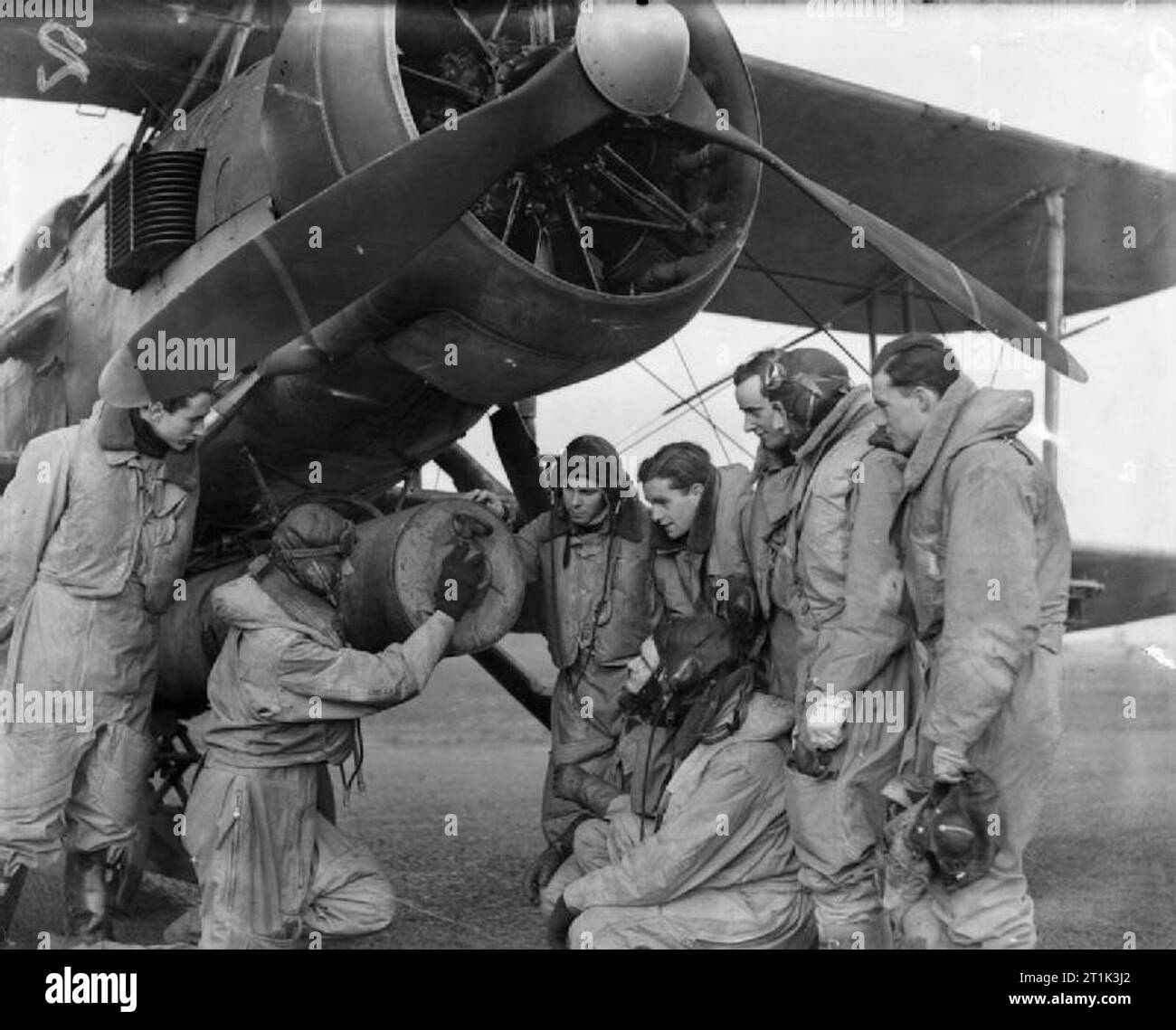 The Royal Navy during the Second World War Members of the Fleet Air Arm in full flying gear being given instruction on torpedo dropping and how the release gear works next to a Fairey Swordfish torpedo bomber at the Fleet Air Arm station HMS JACKDAW at Crail, Scotland. Stock Photo