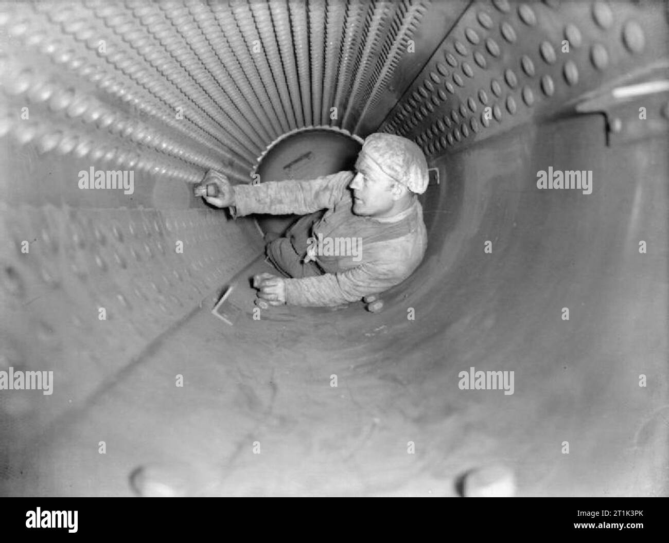 The Royal Navy during the Second World War A stoker cleaning inside the boiler of the cruiser HMS CURACOA at Rosyth. The inside of the boiler is 4 feet in diameter and 12 feet long. Stock Photo
