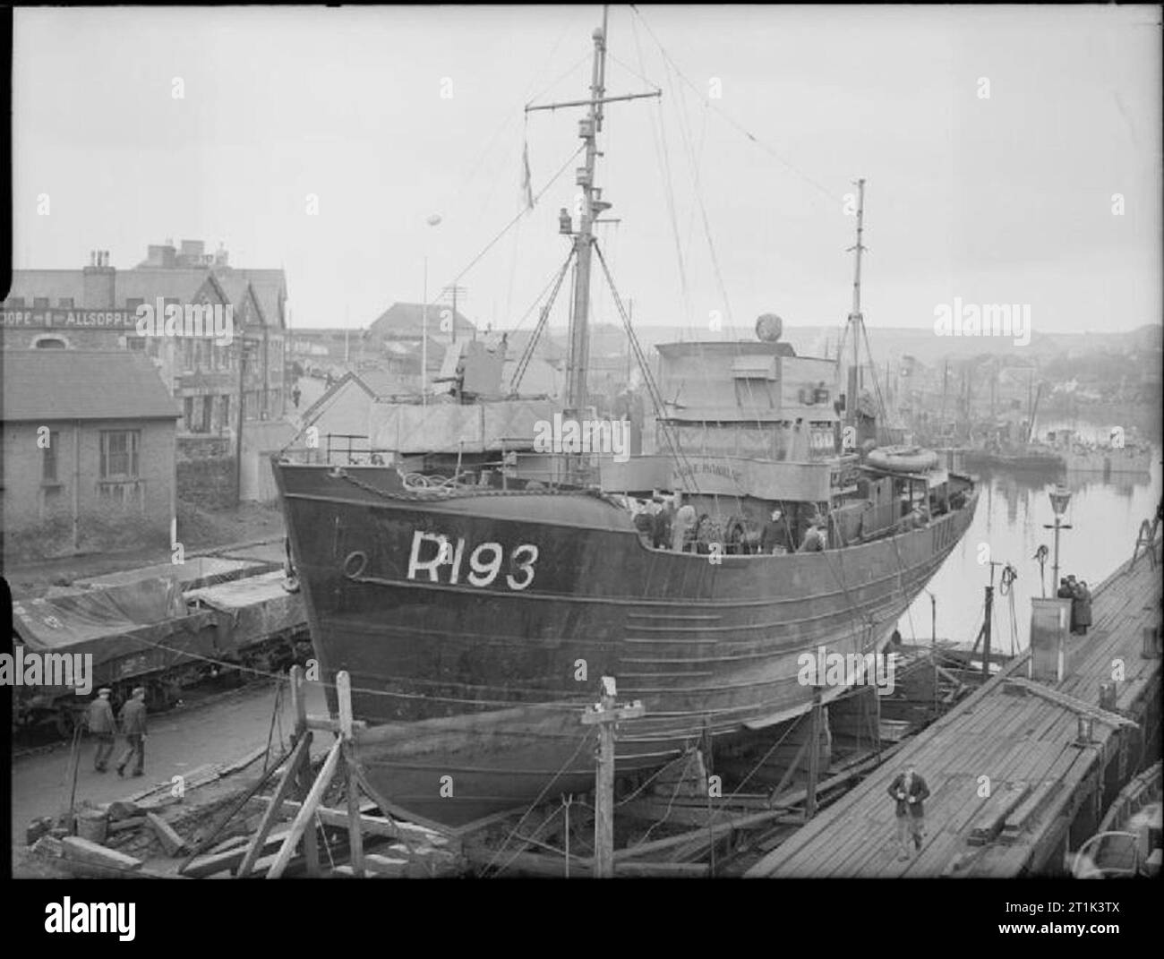 The Royal Navy during the Second World War HMT ANDRE MONIQUE, a Belgian trawler in commision as a HM Patrol Boats in dry dock. This was one of three Belgian fishing trawlers that escaped from the Belgian coast and now help to guard the British coast around Milford Haven and Fishguard. Comments: The boat was stationed at Milford Haven. The ship serverd as an Auxiliary Patrol Vessel in Western Approaches Command (Milford Haven), which was commanded by Rear Admiral P E Phillips DSO Rtd. The photo shows the landing stage, slipway and railway, as seen from Victoria Bridge, Milford Haven. See the 19 Stock Photo