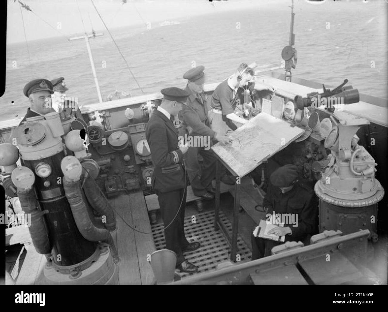 The Royal Navy during the Second World War- the Campaign in Normandy, June 1944 The Royal Navy's big guns support the Allied armies in Normandy as seen on board the cruiser HMS SIRIUS in the Sword area. From information passed by forward observation units operating ashore near the front line, the cruiser's artillery officer; Captain C I Chapman, RA, of Scarborough, Yorks, and Lieutenant F C Boys, RN, of London, the Gunnery Officer, direct the fire of the naval guns. Here they can be seen on the bridge of the cruiser, with a map of the beaches in front of them. Stock Photo