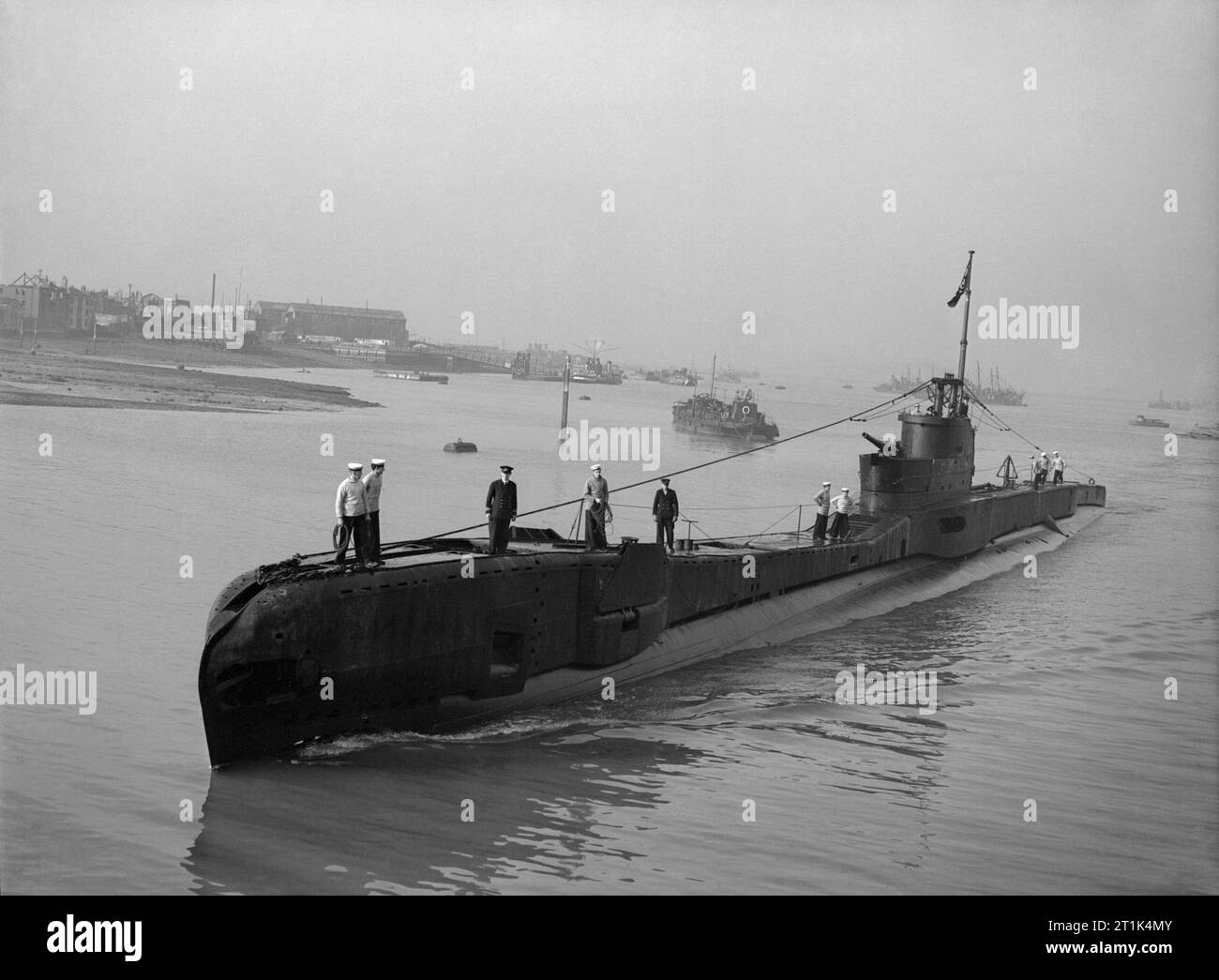 HM Submarine TAKU returns home after a year's successful service in the Mediterranean, 3 August 1943. HMSM TAKU returns home after a year's successful service in the Mediterranean under the command of Lt A J Pitt RN. Earlier in the war, after torpedoing a large supply ship off the Norwegian Coast, TAKU was forced to lie for four hours on the sea bed while the enemy rained down 'a perfect avalanche of depth charges'. Following the sinking of a medium supply ship in the Aaegean Sea, she had to remain submerged for 36 hours because the captain could not risk the noise of the blowers to clear the Stock Photo