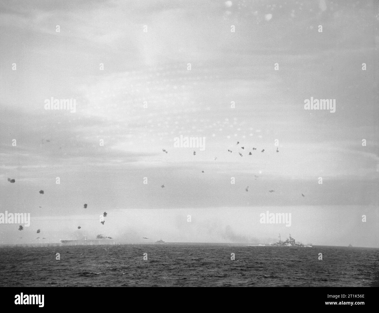 HMS ARK ROYAL and HMS RENOWN firing at Italian torpedo bombers during an attack on a British convoy off Sicily, April 1941. In the distance HMS ARK ROYAL and HMS RENOWN are firing at two Italian torpedo bombers during an attack on a British convoy which was escorted by warships in the Sicilian channel. One is just over the bows of HMS ARK ROYAL and the other is nearer the centre of the picture. Stock Photo