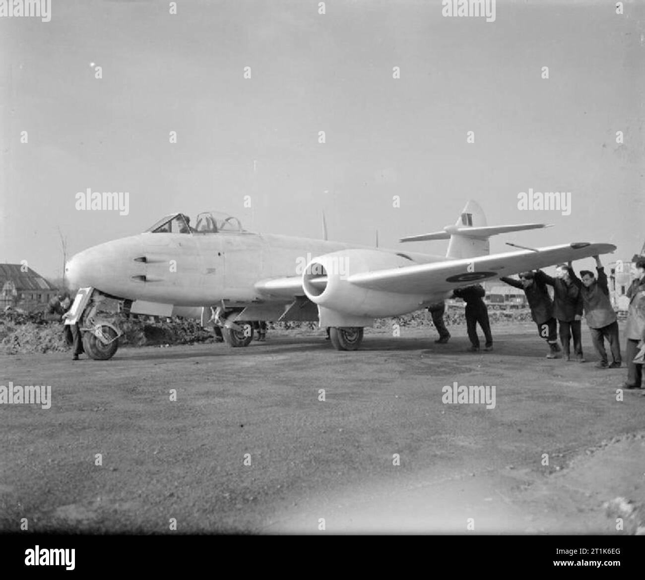 Royal Air Force- 2nd Tactical Air Force, 1943-1945. White-painted Gloster Meteor F Mark III, EE239 'YQ-Q', of No. 616 Squadron RAF Detachment is pushed to its dispersal point at B58/Melsbroek, Belgium. A flight of Meteors was detached from 616 Squadron to 2nd TAF to provide air defence against the Messerschmitt Me 262, being joined by the whole Squadron in March 1945. During the initial deployment, the Meteors were painted white to aid identification by other Allied aircraft. Stock Photo