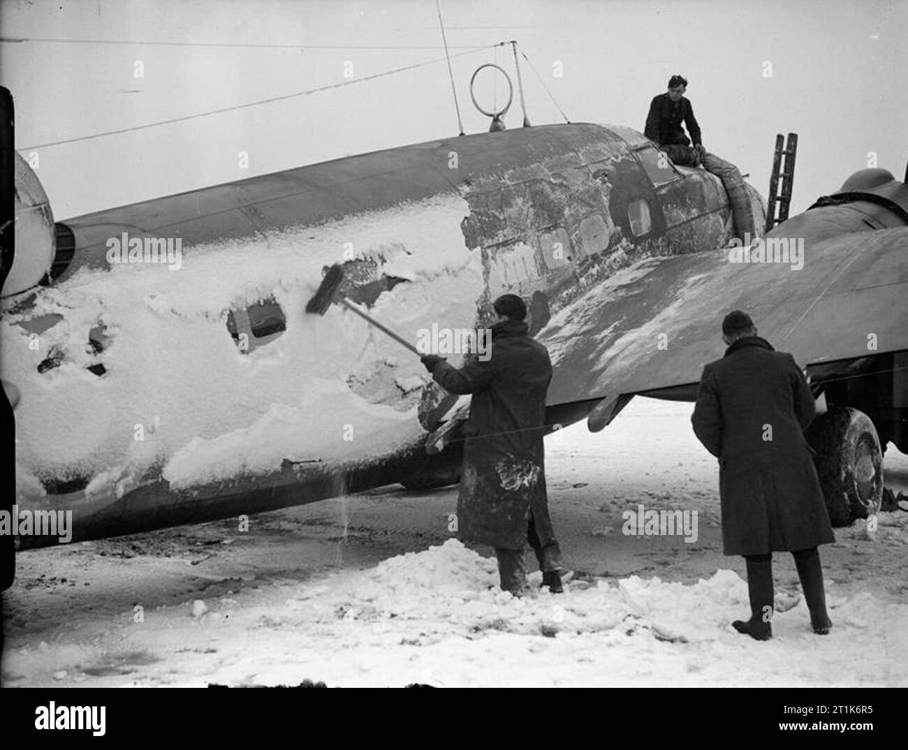 Royal Air Force Coastal Command, 1939-1945. Groundcrew scraping snow from a Lockheed Hudson of No. 233 Squadron RAF at Thorney Island, Hampshire. Stock Photo
