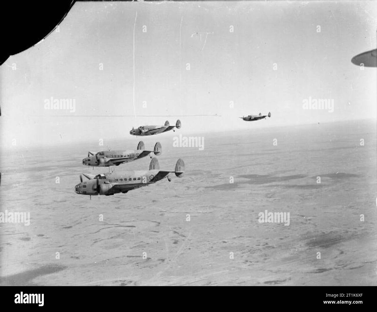 Royal Air Force Operations in the Middle East and North Africa, 1939-1943. Three Lockheed Hudson Mark VI transports, (including FK507 'KW-S', EW889 'KW-E' and EW887 'KW-C'), of No. 267 Squadron RAF based at LG224/Cairo West, Egypt, flying troops to Castel Benito, Tripoli, on an Operation HELPFUL flight. Stock Photo