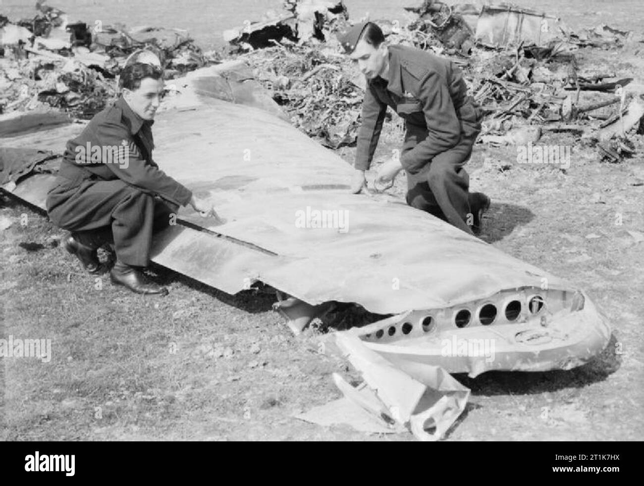 Royal Air Force 1939-1945- Fighter Command Pilot Officer J Allen (right) and Flight Sergeant W Patterson, a No 96 Squadron Mosquito crew based at West Malling, survey the wreckage of the Ju 88 which they shot down near Cranbrook in Kent on the night of 18-19 April 1944. The Junkers was one of eight enemy bombers destroyed by RAF night-fighters that night, during the last Operation Steinbock raid on London. The Ju 88A-4 belonged to 6 staffel KG 6 (Kampfgeschwader 6). The machine was code 3E+BP Werknummer 2537. Unteroffizier Helmut Barbauer and Unteroffizier Friedrich Schork were taken prisoner. Stock Photo