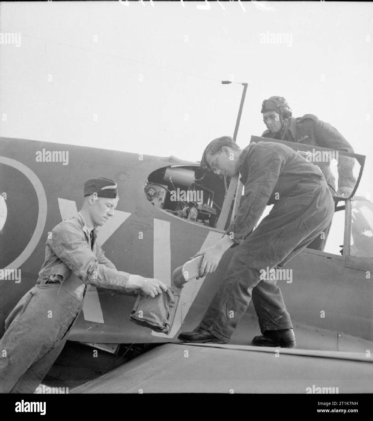 Royal Air Force Army Co-operation Command, 1940-1943. Photographic staff transfer the film magazine of an Type F.24 aerial camera, mounted in the oblique position in a North American Mustang of No. 2 Squadron RAF, to its carrying case for rapid development by the Photographic Section, following a tactical reconnaissance training sortie, at Sawbridgeworth, Hertfordshire. Stock Photo