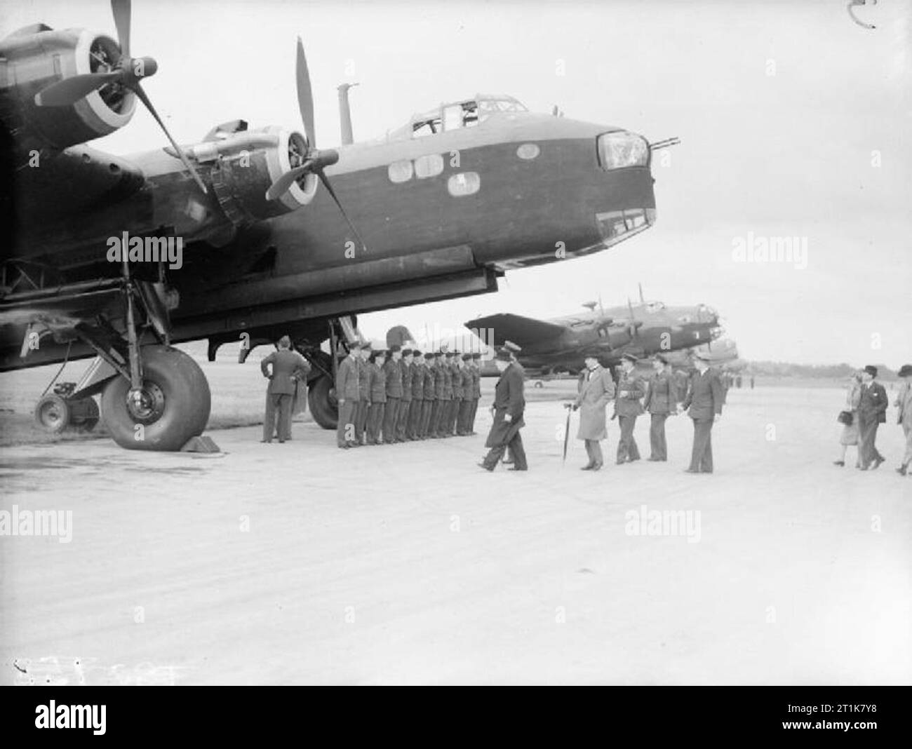 Royal Air Force Bomber Command, 1939-1941. The Prime Minister, Winston Churchill, and his party approach a Short Stirling Mark I of No. 7 Squadron RAF with its air and ground crew lined up for inspection, during a review of British and American bombers in service with the RAF at Northolt, Middlesex. Accompanying the Prime Minister, but obscured by him, is Air Chief Marshal Sir Charles Portal, Chief of the Air Staff, followed by Sir Archibald Sinclair, Secretary of State for Air and Air Vice-Marshal Trafford Leigh-Mallory, Air Officer Commanding No. 11 Group, Fighter Command. The aircraft lined Stock Photo