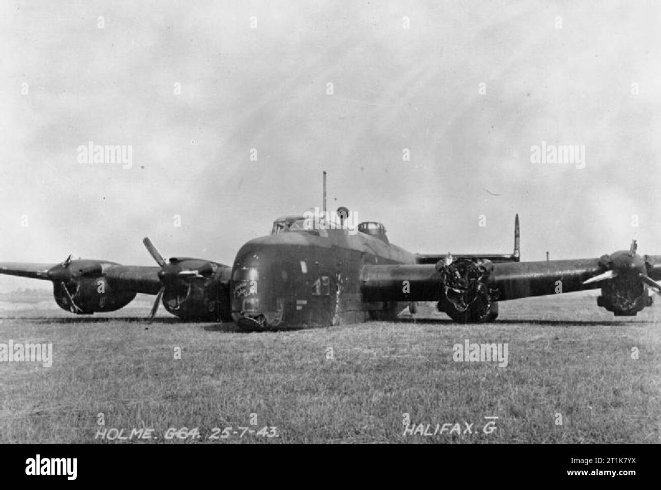 Royal Air Force Bomber Command, 1942-1945. Handley Page Halifax B Mark II Series I (Special), DK148 'MP-G' 'Johnnie the Wolf', of No. 76 Squadron RAF rests at Holme-on-Spalding Moor, Yorkshire, after crash-landing on return from an operation to Essen on the night of 25/26 July 1943. The propeller from the damaged port-inner engine flew off shortly after the bombing run, tearing a large hole in the fuselage. The mid-upper gunner immediately baled out, but the pilot, Flight Lieutenant C M Shannon, regained control of the aircraft and managed to bring the rest of the crew back to Holme, although Stock Photo