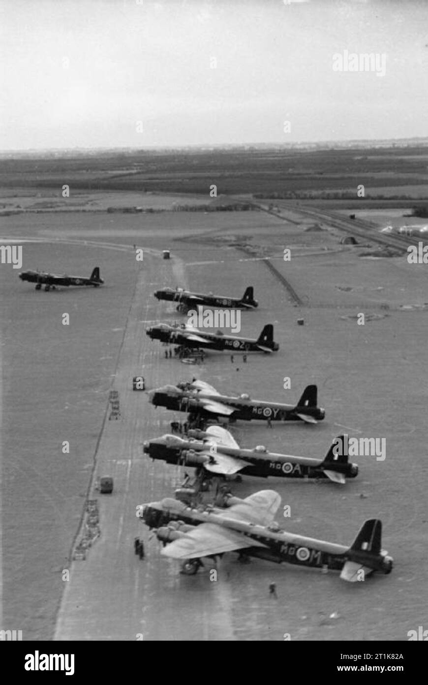 Royal Air Force Bomber Command, 1939-1942. Oblique aerial photograph showing Short Stirling B Mark Is of No. 7 Squadron RAF, lined up on the perimeter track on the north-eastern side of the airfield at Oakington, Cambridge, for a night raid on Dortmund, Germany. The Cambridge-Huntingdon railway line, skirting the eastern boundary of the airfield, can be seen at upper left. Stock Photo