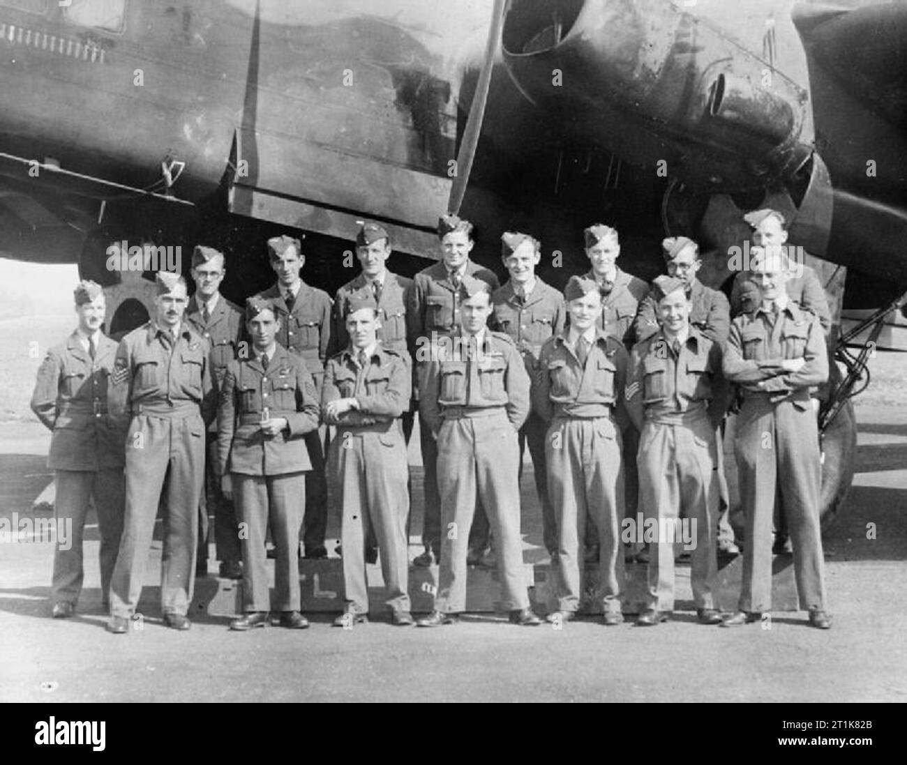 Royal Air Force Bomber Command, 1939-1941. Flying Officer Leonard Cheshire, while serving his second tour of operations with No. 35 Squadron RAF, stands with his air and ground crews in front of a Handley Page Halifax at Linton-on-Ouse, Yorkshire. Stock Photo