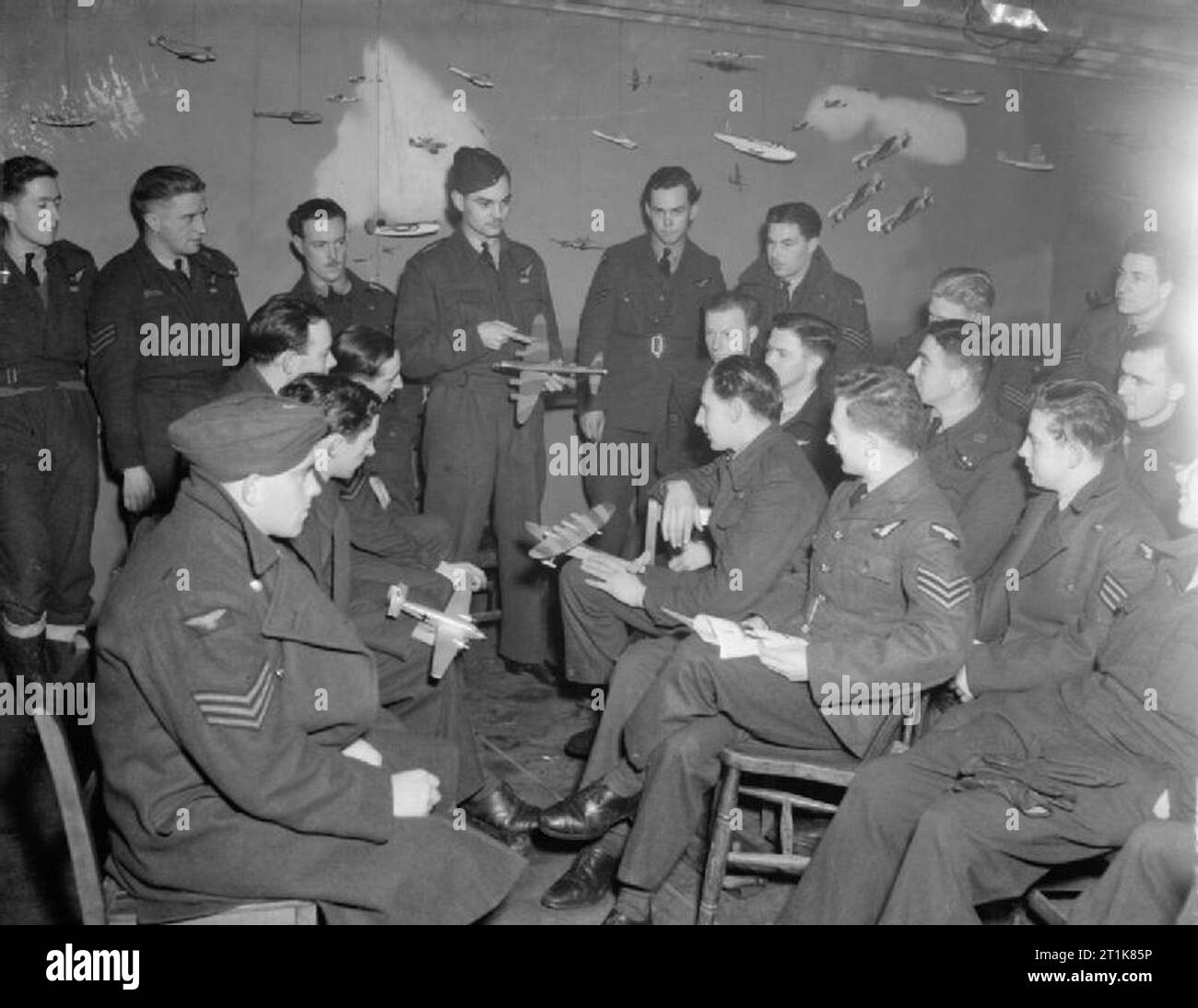 Royal Air Force Bomber Command, 1942-1945. Air gunners attend a refresher class in aircraft recognition conducted by a Gunnery Instructor, Pilot Officer V A Reed, using wooden models, at No. 7 Air Gunners School, Stormy Down, Glamorgan. Stock Photo