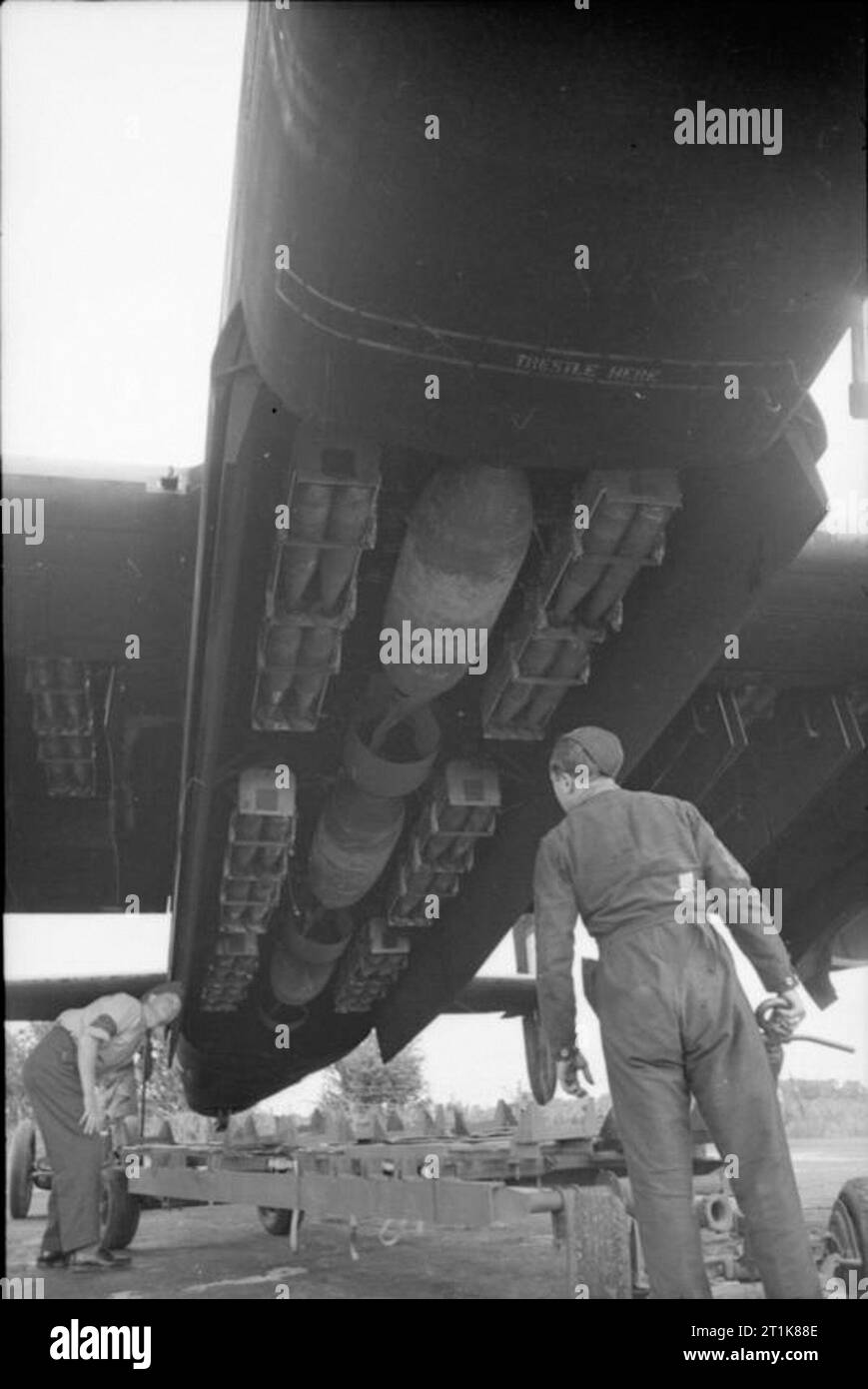 Royal Air Force Bomber Command, 1942-1945. Armourers check over a mixed bomb load of three 1,000-lb MC bombs and small bomb containers (SBCs) filled with 30-lb incendiary bombs, loaded into the bomb-bay and wing cells of a Handley Page Halifax Mark II of No. 405 Squadron RCAF at Pocklington, Yorkshire. Stock Photo