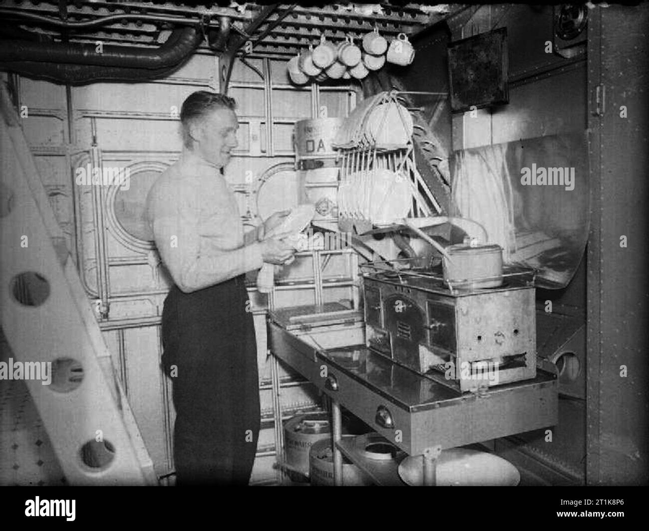 Royal Air Force Coastal Command, 1939-1945. The cook on board a Short Sunderland Mark I of No. 210 Squadron RAF based at Oban, Argyllshire, washes up in his galley. Stock Photo