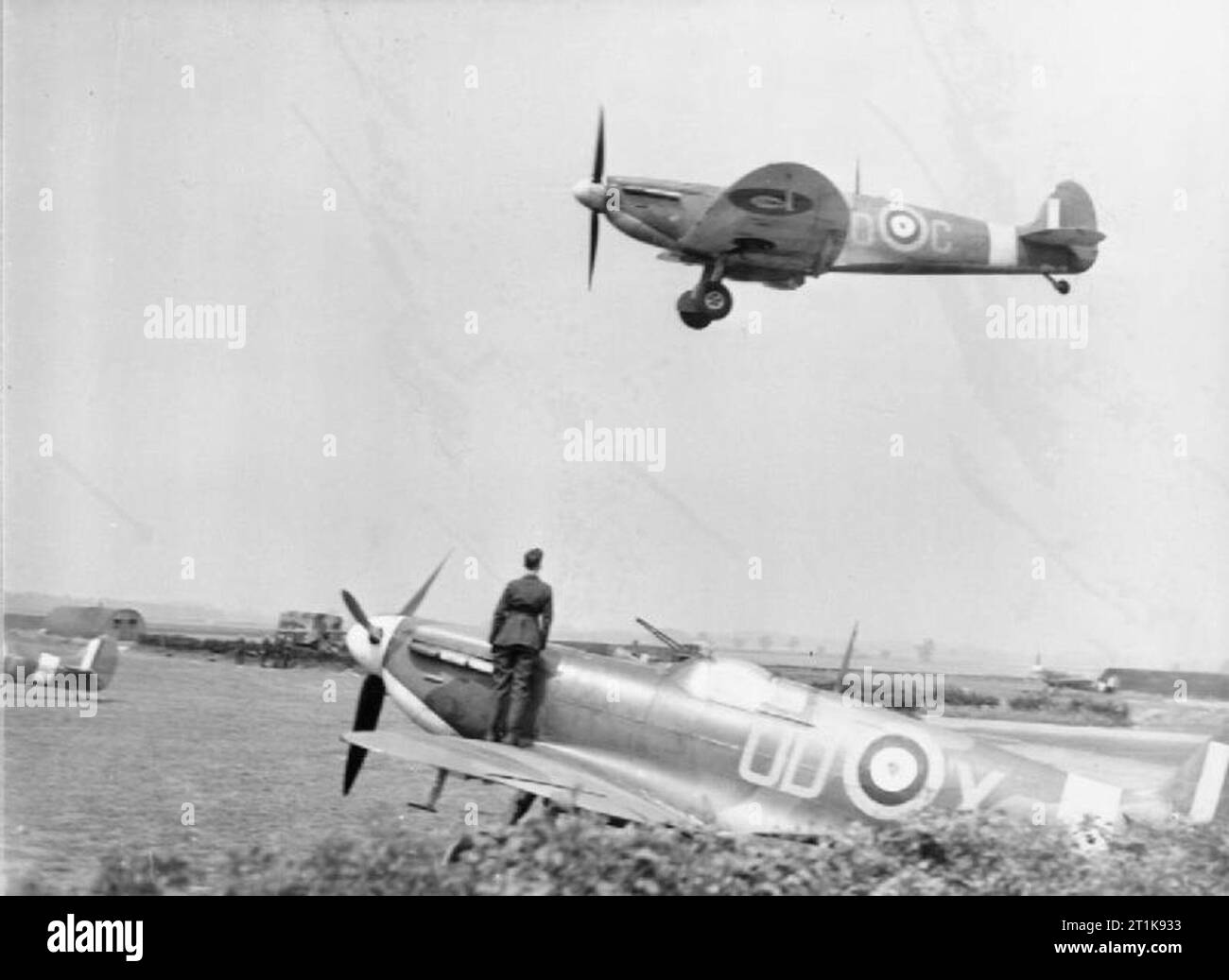 Royal Air Force Fighter Command, 1939-1945. A Supermarine Spitfire Mk IIA of No. 452 Squadron RAAF landing at Kirton-in-Lindsey, Lincolnshire, over other aircraft parked in the 'B' Flight dispersals. Stock Photo