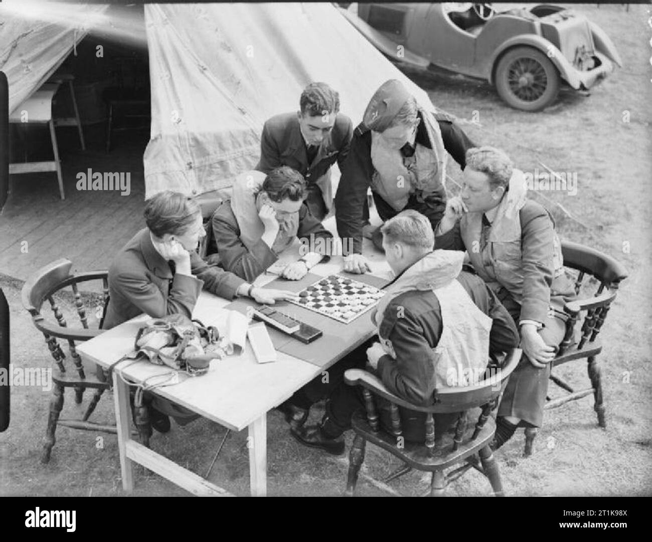 Royal Air Force Fighter Command, 1939-1945. Pilots and gunners of No 264 Squadron RAF, pass the time with a game of draughts while waiting at readiness outside their dispersal tent at Kirton-in-Lindsey, Lincolnshire. Stock Photo