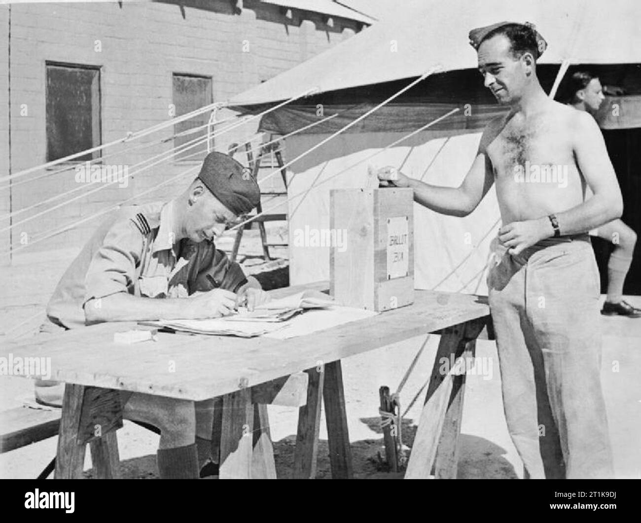 Royal Air Force in the Middle East, 1944-1945. Leading Aircraftman McLeash of Musselburgh, Scotland, serving with an RAF Squadron in North Africa, drops his paper into the ballot box outside a polling booth marquee, during voting for the 1945 General Election. Stock Photo