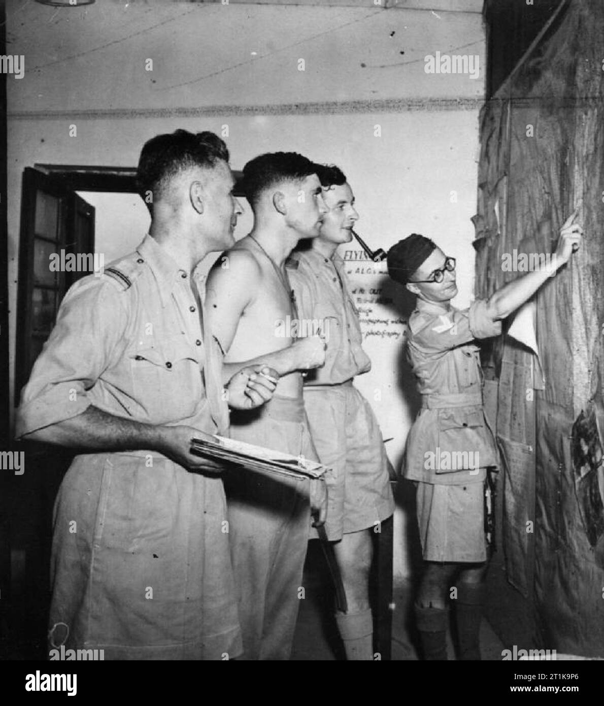 Royal Air Force Operations in the Far East, 1941-1945. Aircrew of No. 684 Squadron RAF, attend a briefing on the weather before taking off on a photo-reconnaissance sortie at Alipore, India. Corporal Taylor (right) explains the meteorological situation to Wing Commander W B Murray, the Commanding Officer of the Squadron (smoking pipe), Flight Lieutenant N Ribison and Flying Officer B Redfern.. Stock Photo