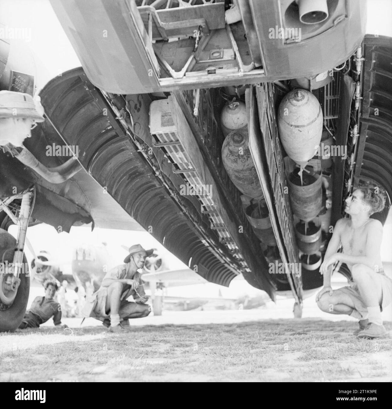 Royal Air Force Operations in the Far East, 1941-1945. Leading Aircraftman W T Messenger of Barry, South Wales and Aircraftman R J Frost of Brynmill, Swansea, check over the a load of 1,000-lb HE and Small Bomb Containers (SBC) filled with 4lb incendiaries in the bomb bay of a Vickers Wellington Mark X of No. 99 Squadron RAF at Jessore, India, prior to a sortie over Burma. Stock Photo