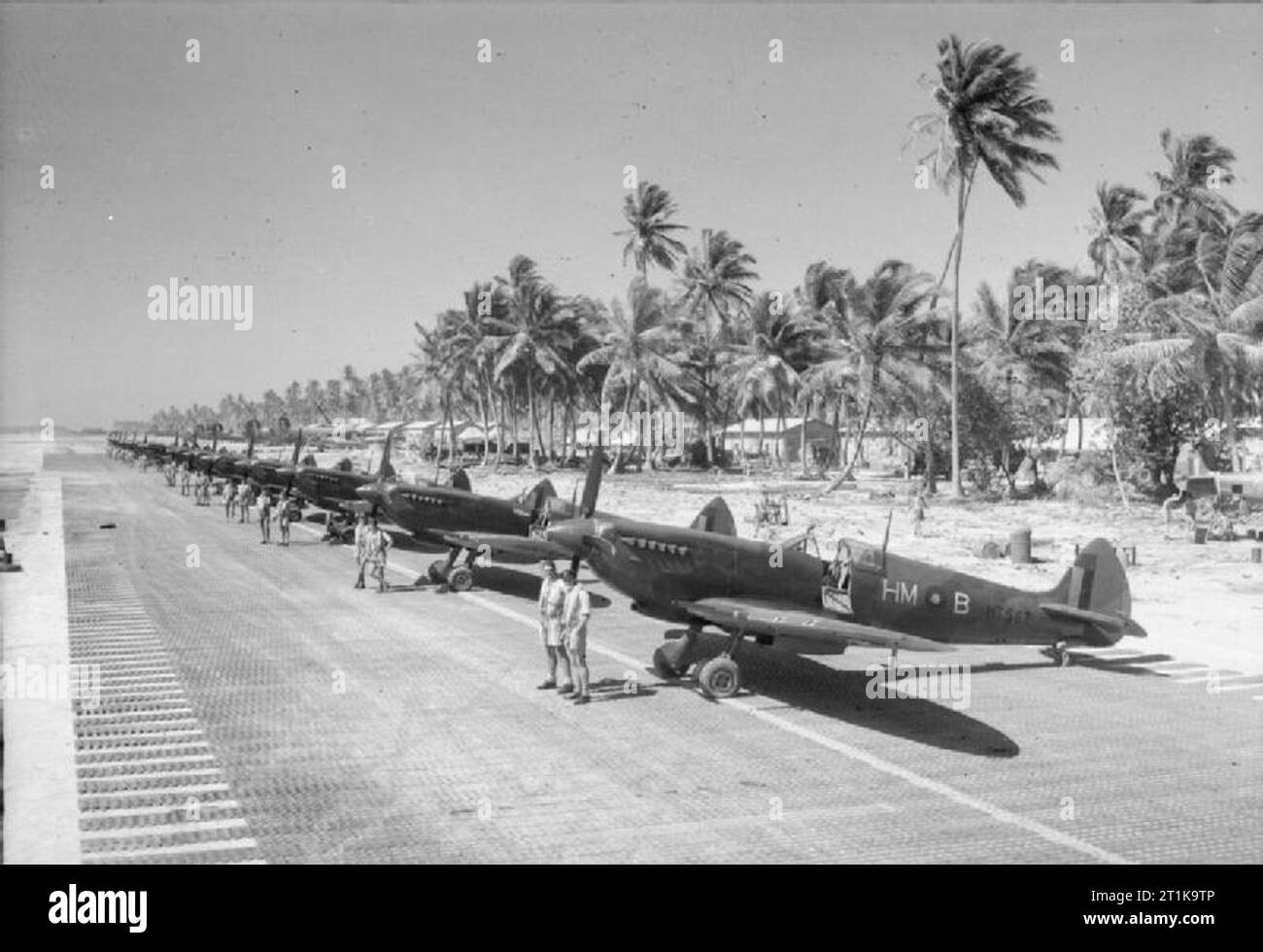 Royal Air Force Operations in the Far East, 1941-1945 Spitfire Mk VIIIs and personnel of No. 136 Squadron RAF lined up on a recently-laid PSP airstrip on Brown's West Island, Cocos Islands, in the Indian Ocean. Stock Photo