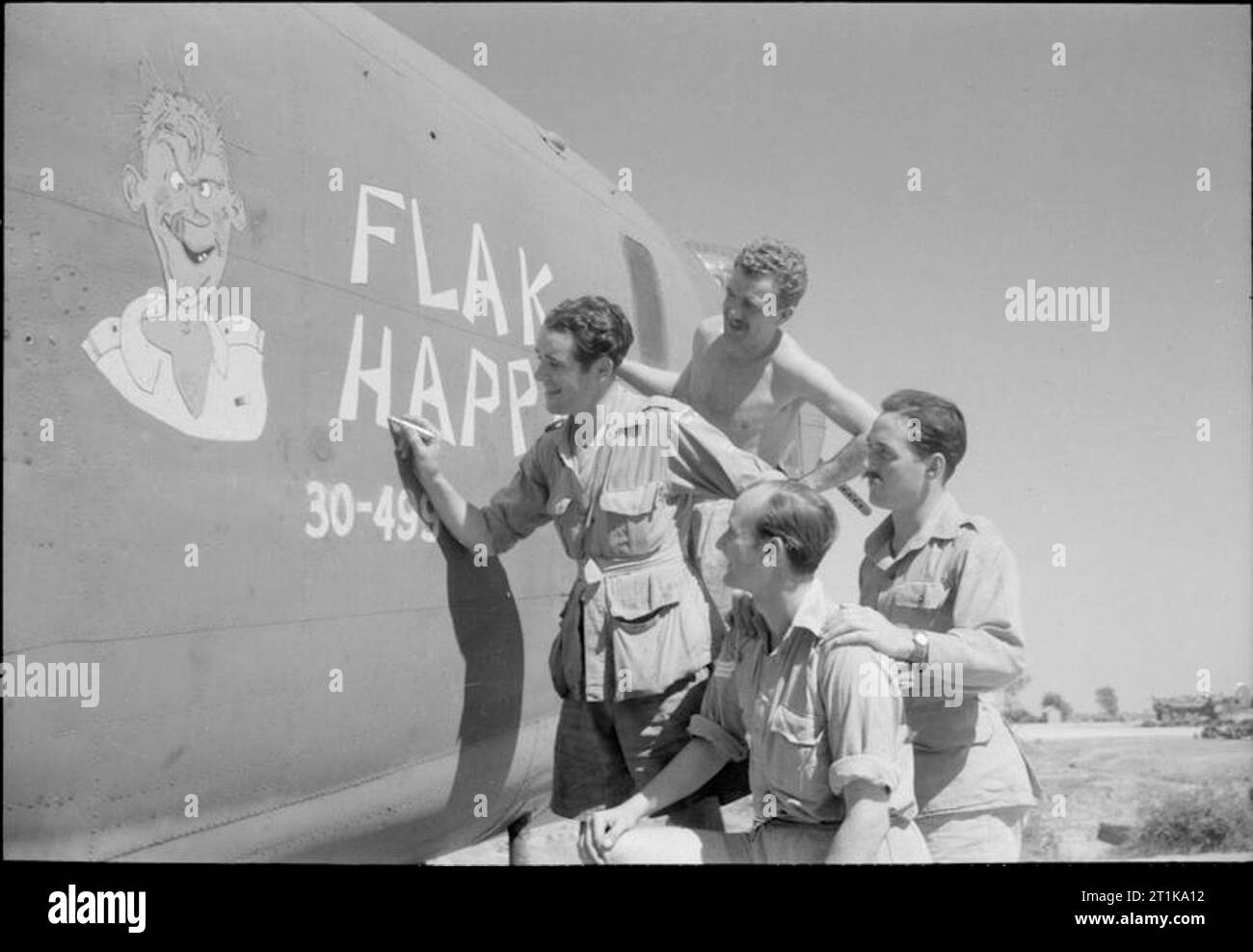 Royal Air Force Operations in the Far East, 1941-1945. Air and ground crews of 'Flak Happy', a Consolidated Liberator B Mark VI of No. 215 Squadron RAF, put the finishing touches to the nose art on the side of the fuselage, at Dhubalia, India. Stock Photo