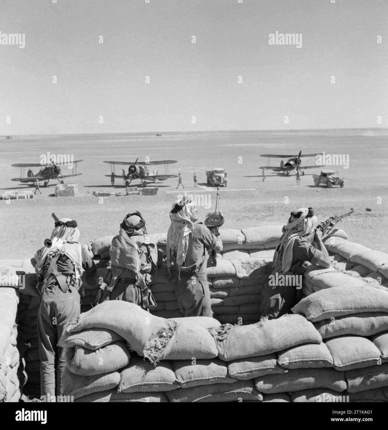 Royal Air Force Operations in the Middle East and North Africa, 1939-1943. Arb Legionnaires guard the landing ground at H4 pumping station on the Iraq Petroleum Company pipeline in Transjordan, as Gloster Gladiators of No. 94 Squadron RAF Detachment refuel during their journey from Ismailia, Egypt, to reinforce the besieged garrison at Habbaniyah, Iraq. On arrival at Habbaniyah these aircraft formed No. 1 Flight of 'A' Squadron for operations against the Iraqi rebels. Stock Photo