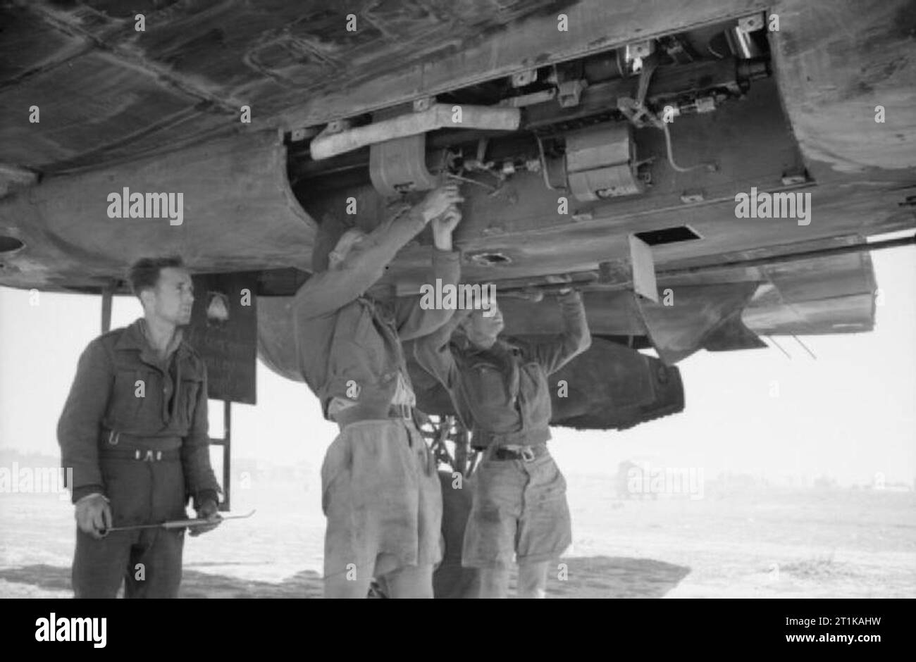 Royal Air Force Operations in the Middle East and North Africa, 1939-1943. Armourers of No. 89 Squadron RAF servicing the 20mm Hispano cannons of a Bristol Beaufighter Mark VIF at Castel Benito, Libya. Stock Photo