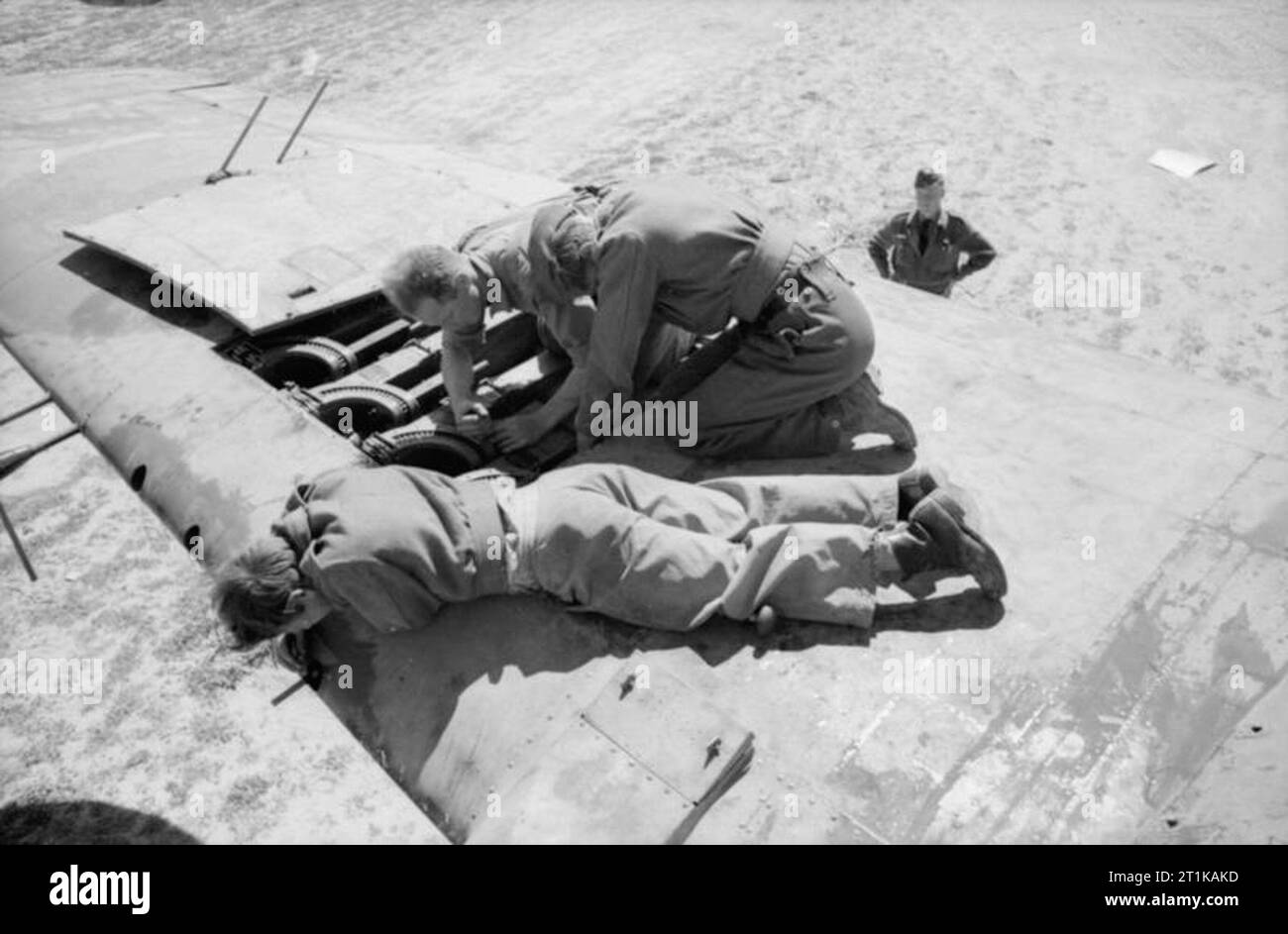 Royal Air Force Operations in the Middle East and North Africa, 1939-1943. Armourers of No. 89 Squadron RAF installing a .303 Browning machine gun in the wing of a Bristol Beaufighter Mark VIF at Castel Benito, Libya. Stock Photo