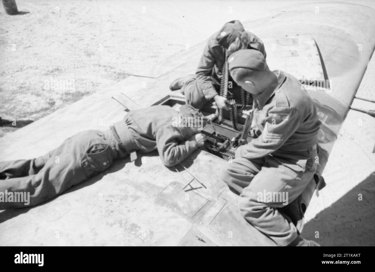 Royal Air Force Operations in the Middle East and North Africa, 1939-1943. Armourers of No. 89 Squadron RAF aligning and loading .303 Browning machine guns in the wing of a Bristol Beaufighter Mark VIF, before the firing butts at Castel Benito, Libya. Stock Photo