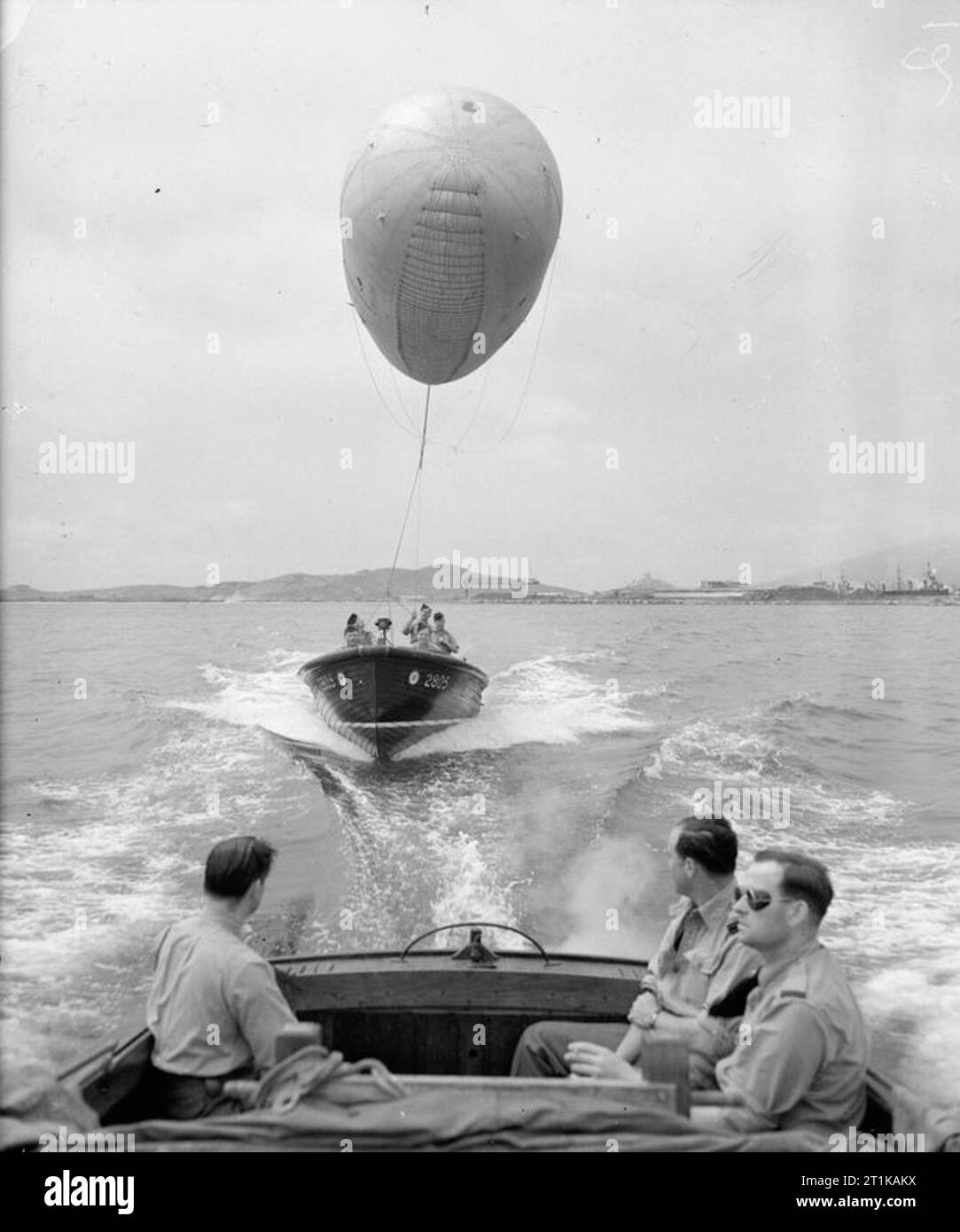 Royal Air Force Operations in the Middle East and North Africa, 1939-1943. Airmen of No. 985 (Balloon) Squadron RAF transferring a Mark VI Kite Balloon to a merchant ship in Bone harbour, Algeria, by towing it to the vessel in a 24-foot Marine Tender. Stock Photo