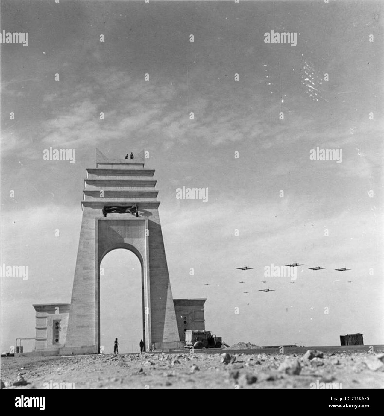 Royal Air Force Operations in the Middle East and North Africa, 1939-1943. Curtiss Kittyhawks of No. 239 Wing RAF fly into Marble Arch landing ground, past the Arco dei Fileni, ('Marble Arch') a monument erected on the Via Balbia, the coastal road in Libya between the provinces of Tripolitania and Cyrenaica, to celebrate early Italian Fascist victories. Stock Photo