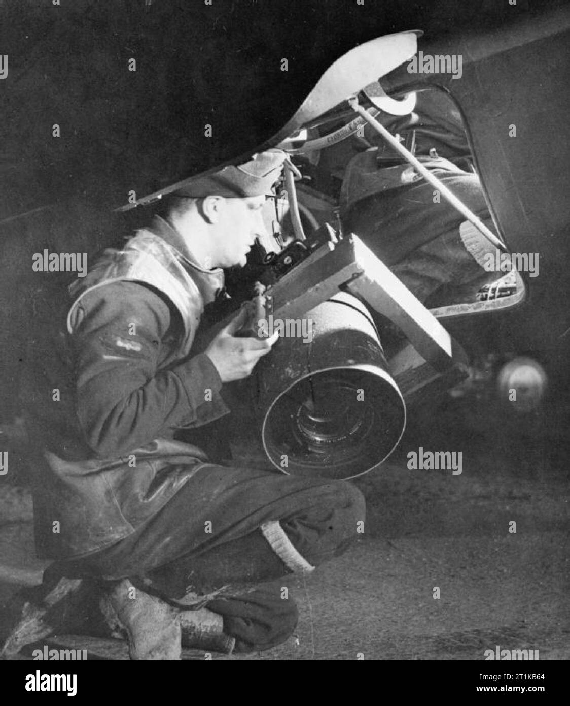Royal Air Force- 2nd Tactical Air Force, 1943-1945. Leading Aircraftman C Barnham of Winchmore Hill, London, loads a Fairchild K-19B (12-inch focal length lens) night aerial camera into a De Havilland Mosquito PR Mark XVI of No. 140 Squadron RAF, at B58/ Melsbroek, Belgium, before a night photographic-reconnaissance sortie. Stock Photo