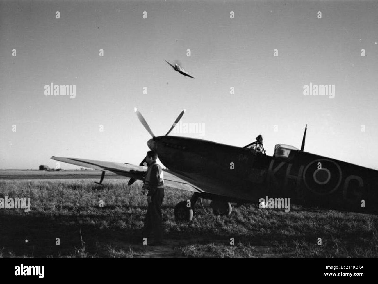 Royal Air Force- 2nd Tactical Air Force, 1943-1945. A Supermarine Spitfire of No. 127 (Canadian) Wing takes off on a dusk patrol from B2/Bazenville, Normandy, while a Spitfire Mark IX of No. 403 Squadron RCAF waits at readiness. Stock Photo