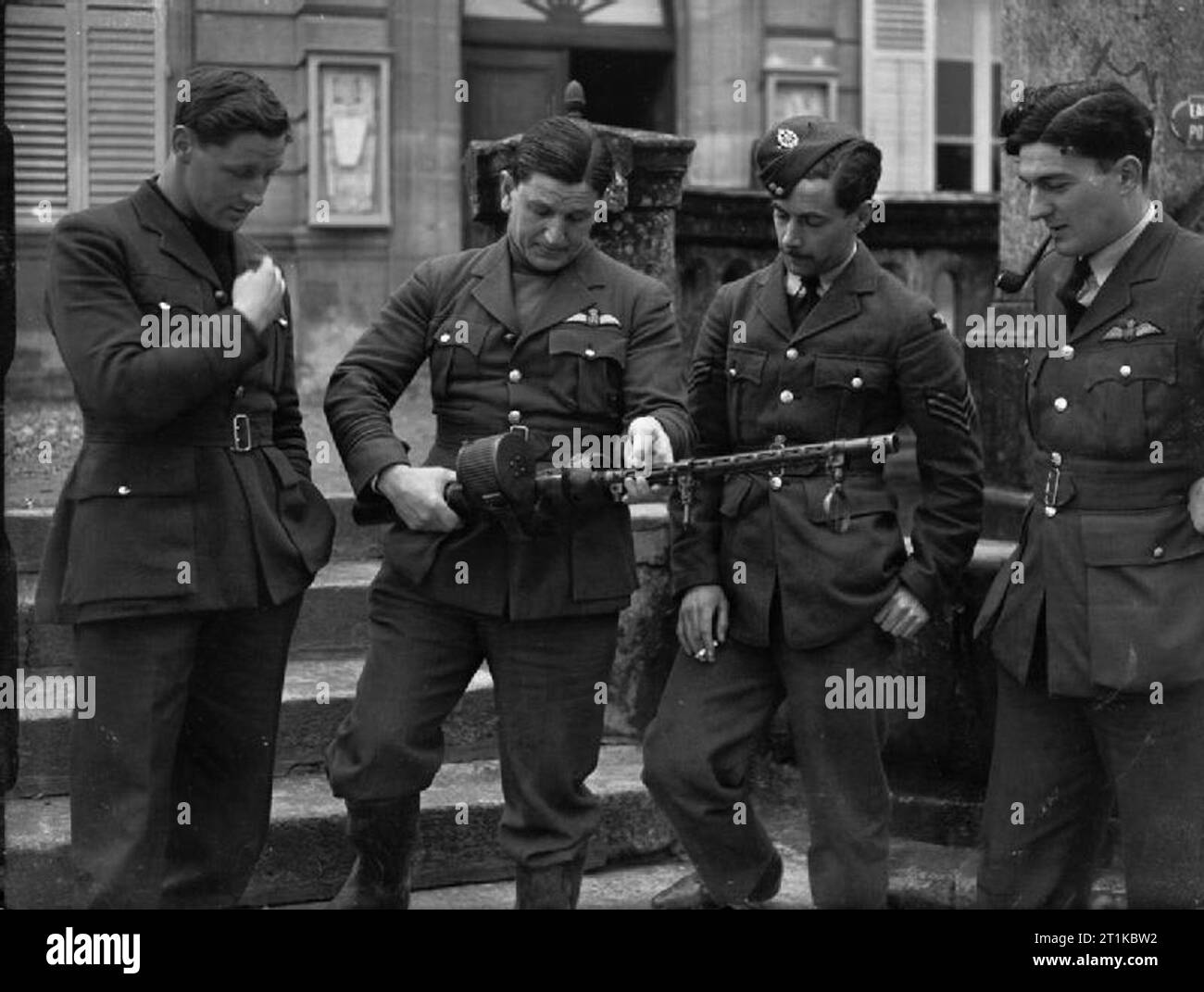 Royal Air Force- France, 1939-1940. Four pilots of No. 1 Squadron RAF study a German 7.9mm machine gun outside the Mairie at Neuville-sur-Ornain, which served as the Officers' Mess while the Squadron was based at Vassincourt: (left to right) Flying Officer P H M Richey Squadron Leader P J H 'Bull' Halahan (Officer Commanding No. 1 Squadron) Sergeant A V 'Darkie' Clowes Flight Lieutenant P R Walker Richey, Clowes and Walker were credited with victories in the Squadron's first aerial combats of the war with enemy fighters, on 29 March 1940 Stock Photo