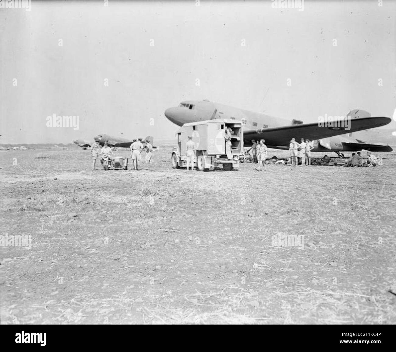 Royal Air Force- Italy, the Balkans and South-east Europe, 1942-1945. A British Army ambulance pulls up in front of a line of Douglas Dakota Mark IIIs at Catania, Sicily, FD986 Stock Photo
