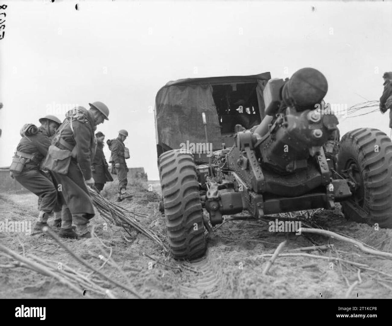 The British Army in France 1940 Gunners of 3rd Medium Regiment, Royal Artillery place brushwood under the wheels of one of their 6-inch howitzers to prevent the wheels sinking into the soft ground as it is towed into position, near Calais, 30 March 1940. Stock Photo