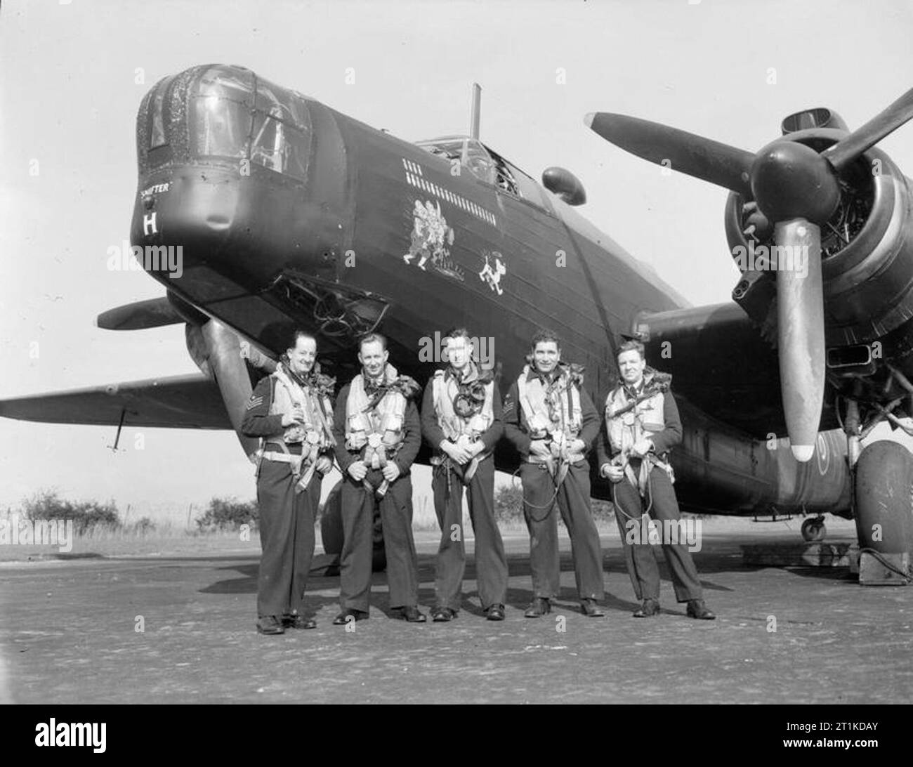The Royal Australian Air Force in Britain, 1943 The first all Australian crew in Bomber Command to complete a tour of operations (with No 466 Squadron, Royal Australian Air Force) stand in front of their Vickers Wellington bomber at RAF Leconfield, Yorkshire. Left to right: Flight Sergeant J P Hetherington (bomb aimer), Pilot Officer A C Winston (rear gunner), Pilot Officer J H Cameron (captain), Flight Sergeant J Samuels (W/O - air gunner), and Pilot Officer J J Allan (navigator). Stock Photo