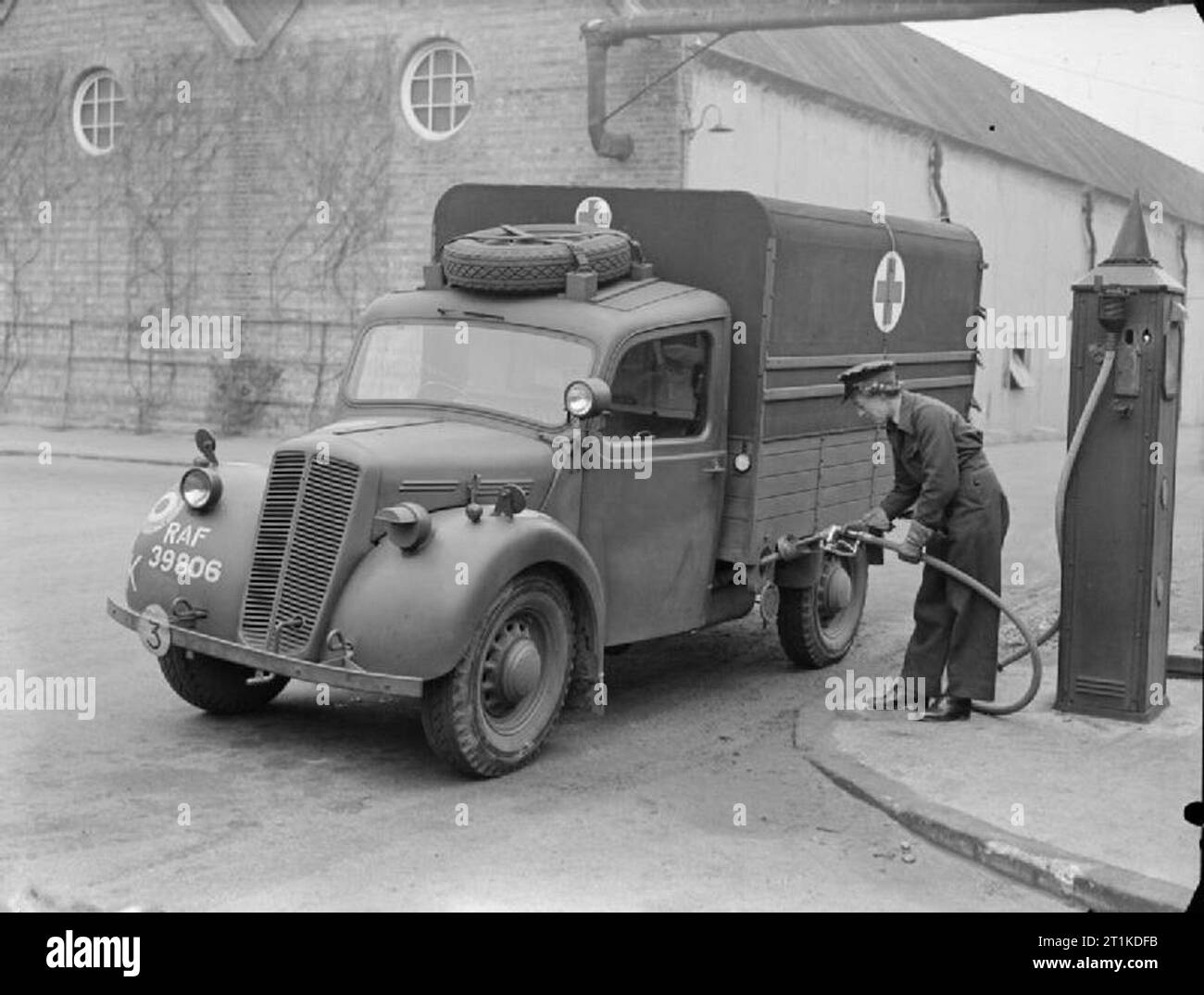 The Women's Auxiliary Air Force, 1939-1945. A WAAF driver refuels her Morris Type 'C' ambulance at a petrol pump outside the workshops at Cardington, Bedfordshire. Stock Photo