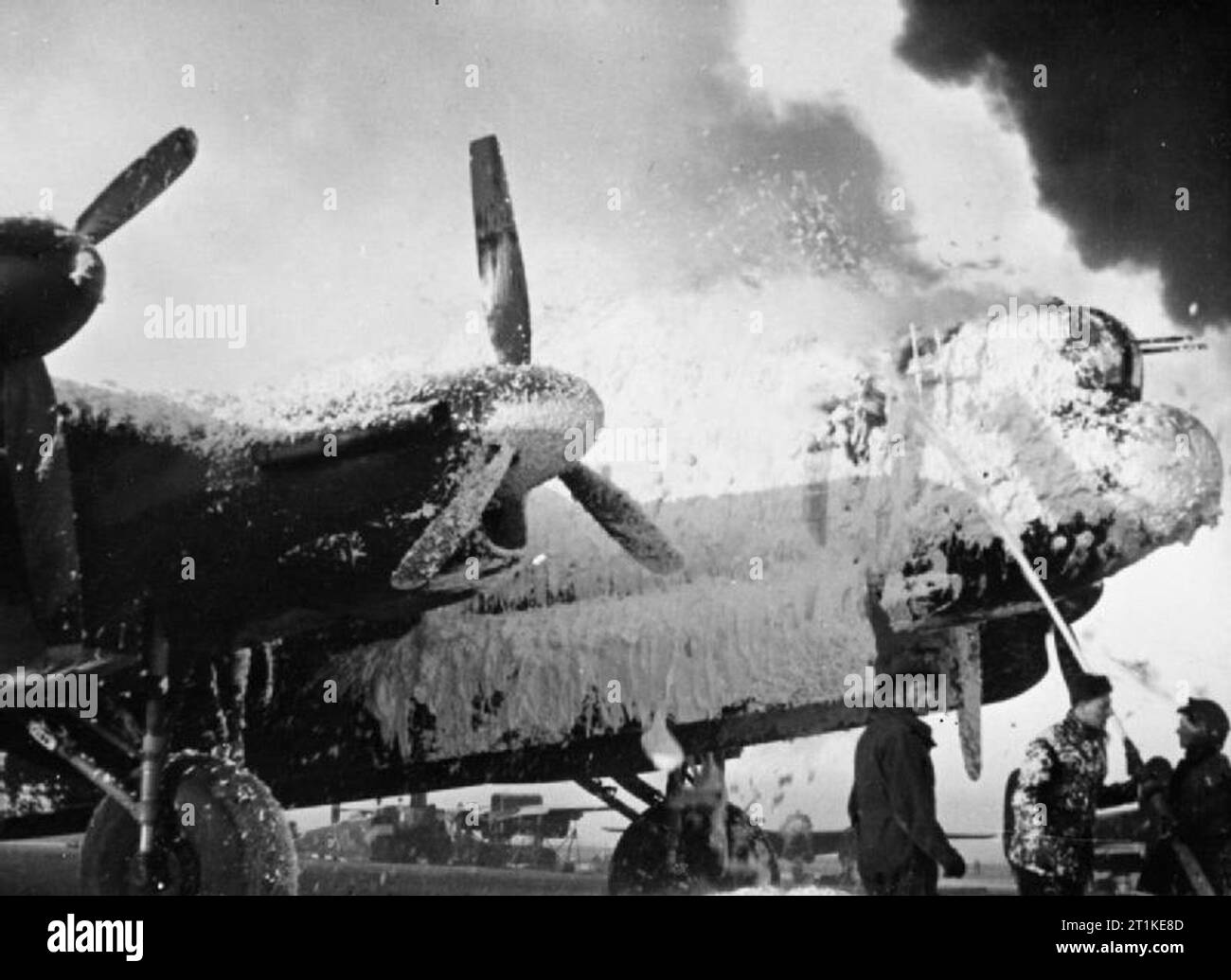 Royal Air Force Bomber Command, 1942-1945. Fire crews cover an Avro Lancaster of Bomber Command with foam in an effort to save it from burning, at B58/Melsbroek, Belgium, following the attack on the airfield by Luftwaffe fighter-bombers, (Operation BODENPLATTE). Stock Photo