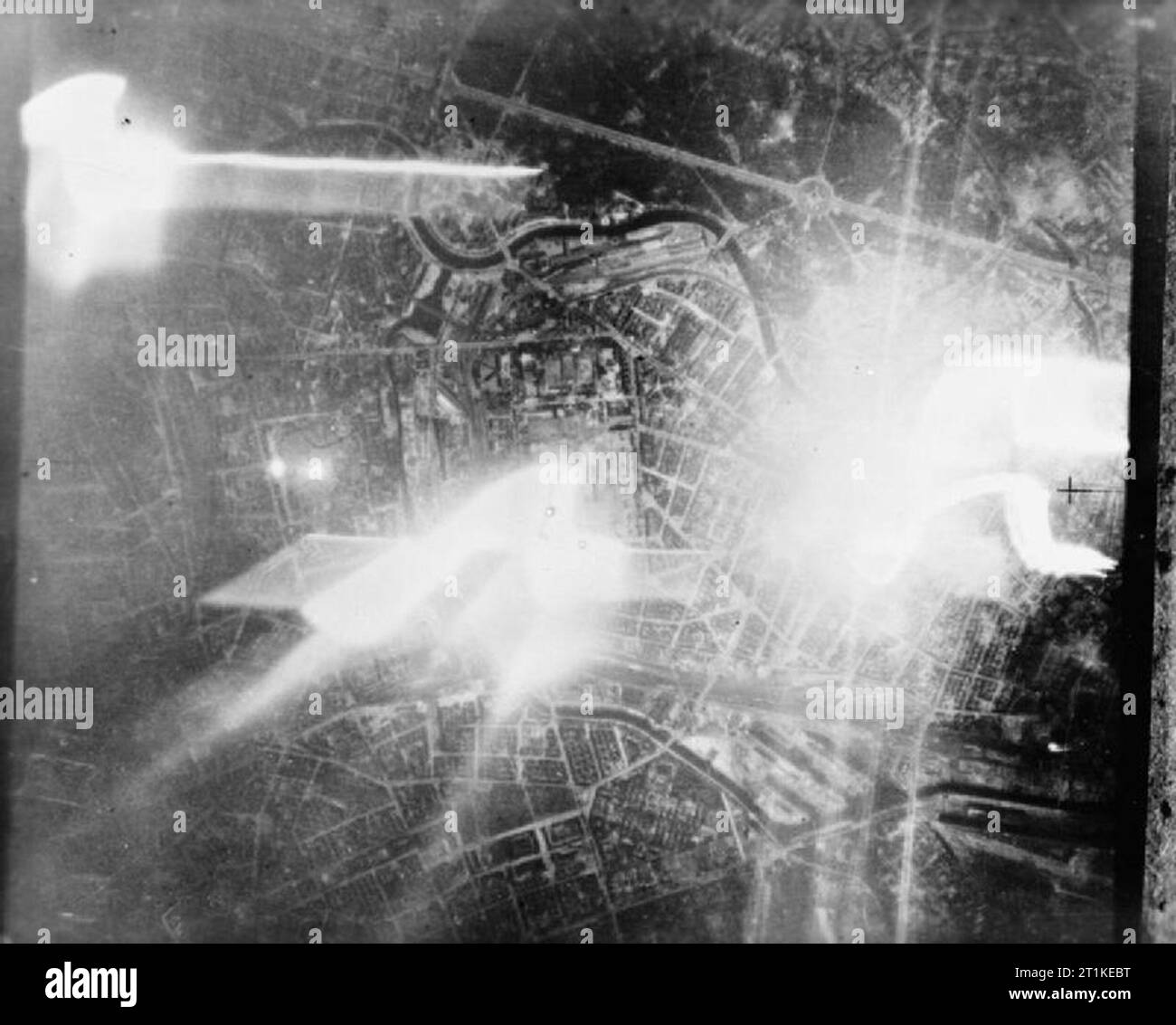 Royal Air Force Bomber Command, 1942-1945. Aerial vertical taken over the Moabit district of Berlin during a raid by 33 De Havilland Mosquitos of the Late Night Striking Force. The track of a falling target indicator (TI) can be seen on the right, illuminating the River Spree,and the Charlottenburger Chaussee, running from top right through the Tiergarten to the Brandenbruger Tor and Unter den Linden. The other light sources are German searchlights. Stock Photo