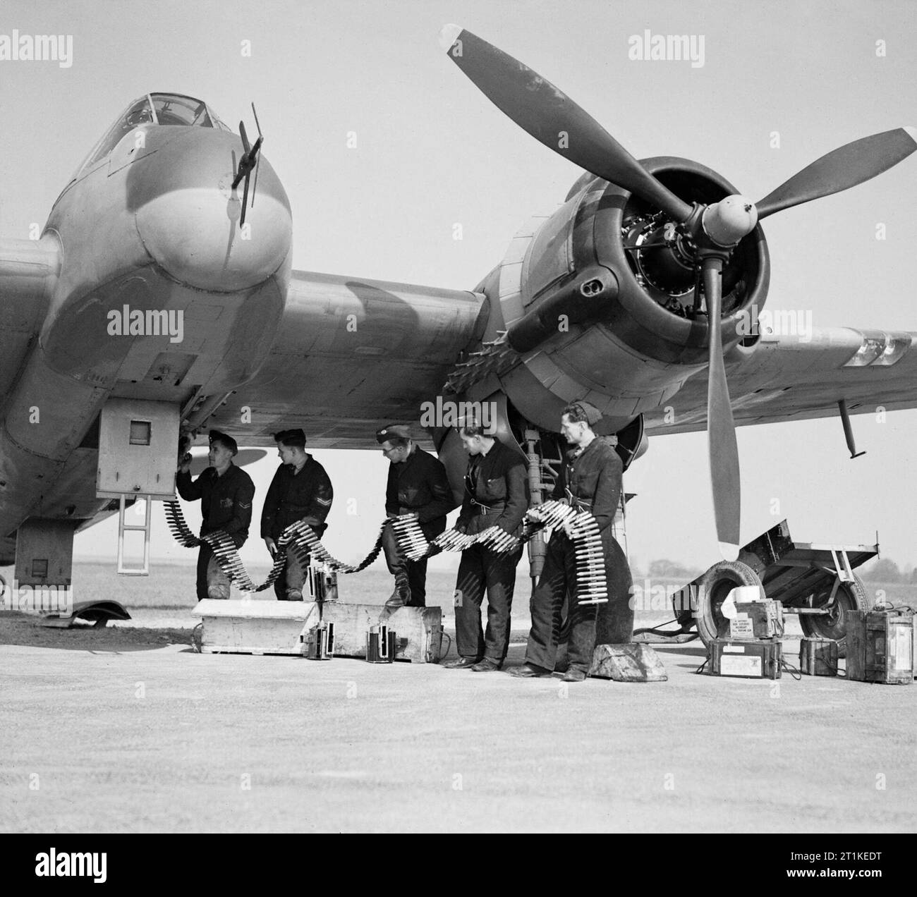 Bristol Beaufighter Mk VIF of No. 96 Squadron RAF being re-armed at Honiley, Warwickshire, 23 March 1943. Beaufighter VIF V8748/ZJ-R of No. 96 Squadron being re-armed at Honiley, 23 March 1943. The armourers are feeding belts of ball and high-explosive incendiary ammunition into the magazines of the aircraft's four 20mm Hispano cannon. Stock Photo