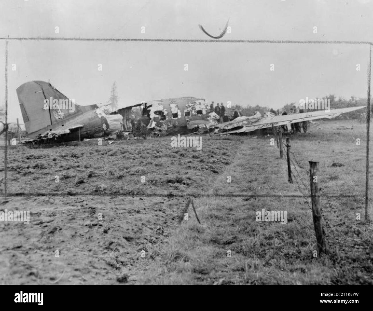 Royal Air Force Transport Command, 1943-1945. Operation MARKET III: air re-supply of British airborne forces in the Arnhem area, 19 September 1944. Burnt-out Douglas Dakota Mark III, KG401, of No. 48 Squadron RAF based at Down Ampney, Gloucestershire, which crash-landed in a field near Kessel, Holland, after parachuting supplies over Arnhem. The aircraft had just dropped its supplies from 700 feet when it was met with intense anti-aircraft fire. The tail unit, rudder, port aileron and engine, the starboard auxiliary fuel tank and all the gyro instruments were either damaged or put out of actio Stock Photo