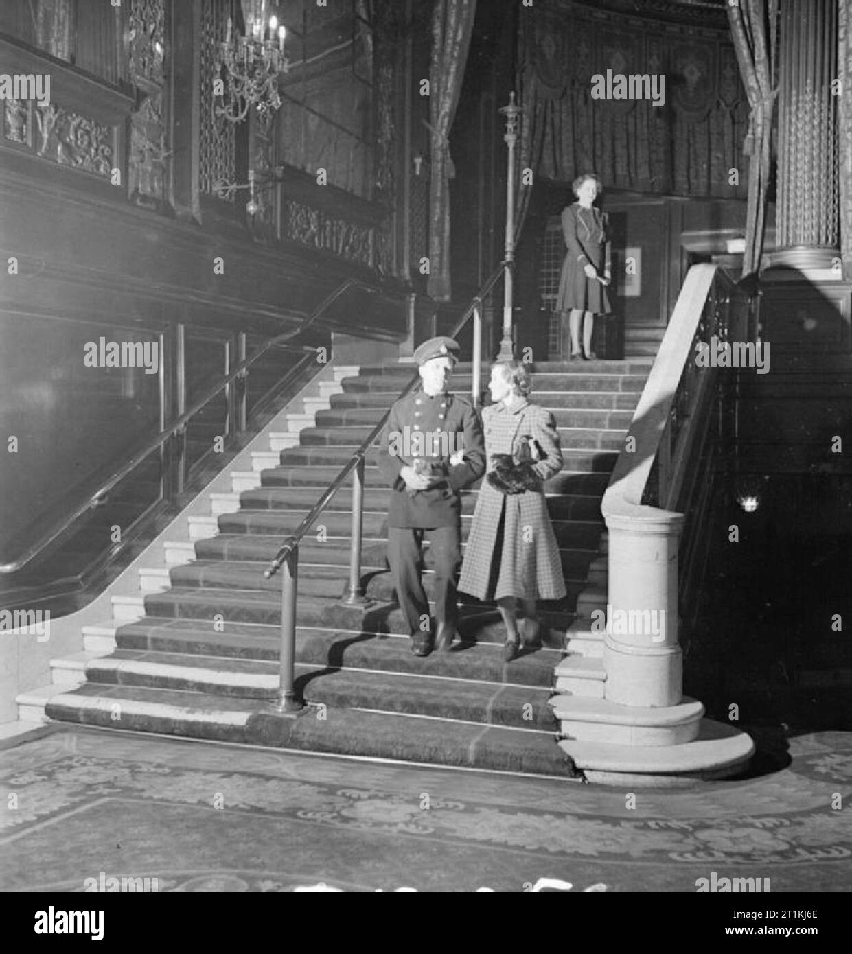 Cinemas and Cinema-going during the Second World War National Fire Service fireman Sydney Chillingworth and his wife Hilda descend the staircase of a cinema, after having seen a film, somewhere in London. An usherette can be seen standing at the top of the stairs. Stock Photo