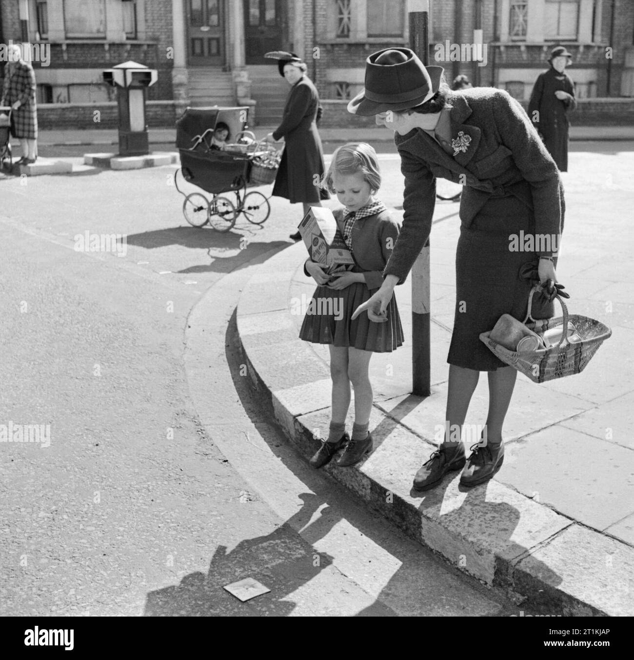 a-mother-teaches-her-daughter-to-cross-the-road-in-safety-during-1942