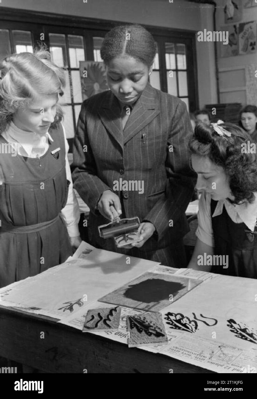 Colonial Students in Great Britain- Students at University of London Institute of Education, London, England, UK, 1946 Miss Kote-Amon from Labadi, Gold Coast, demonstrates the use of lino-cuts to senior girls at the Marlborough Senior Girls School, Isleworth, West London. She is a member of the staff of Kumasi Government School and has won the Gold Coast Teachers Certificate. Stock Photo