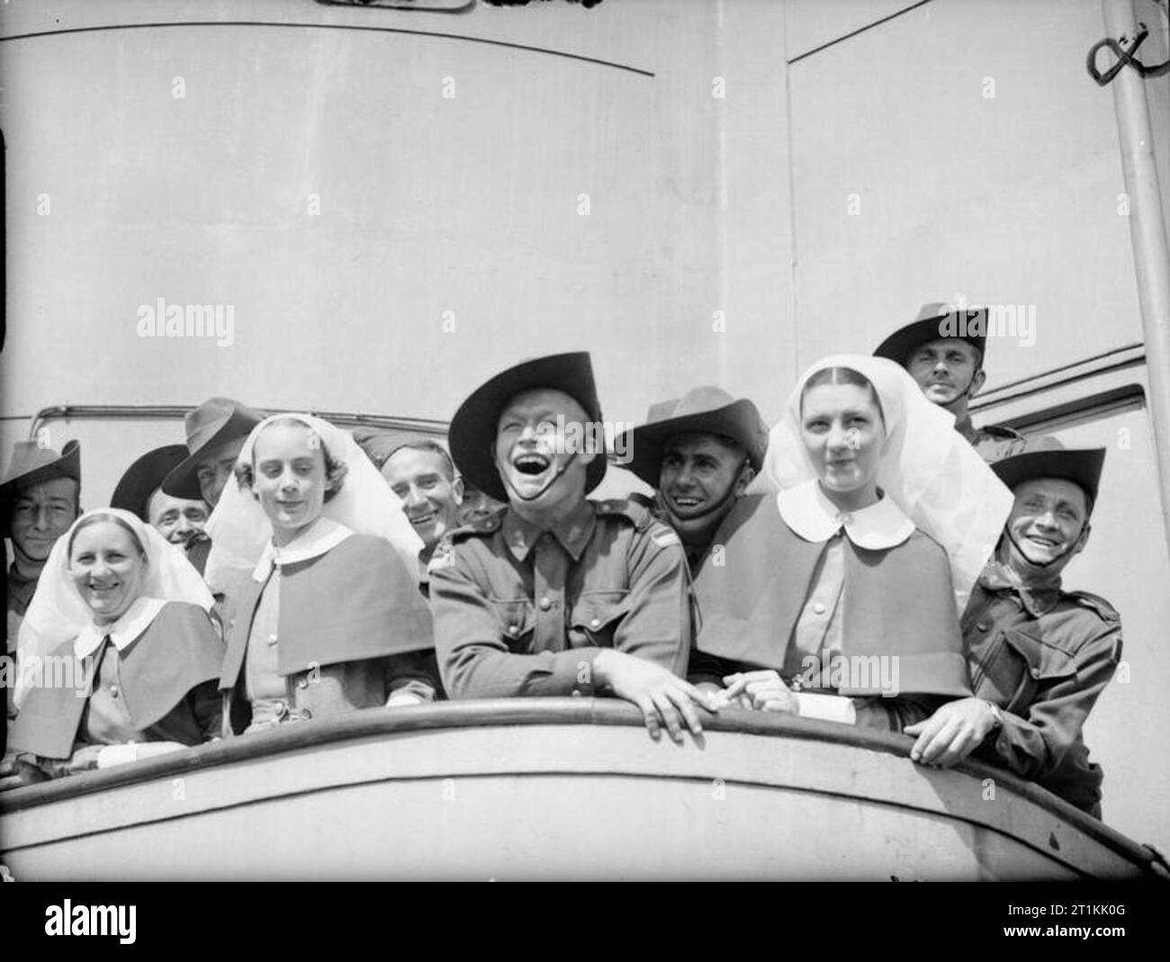 Empire Forces in Great Britain 1939-1945 Troops and nursing sisters of the 2nd Australian Imperial Force line the rails of a troopship as it docks at Gourock on the Clyde, 19 June 1940. Stock Photo