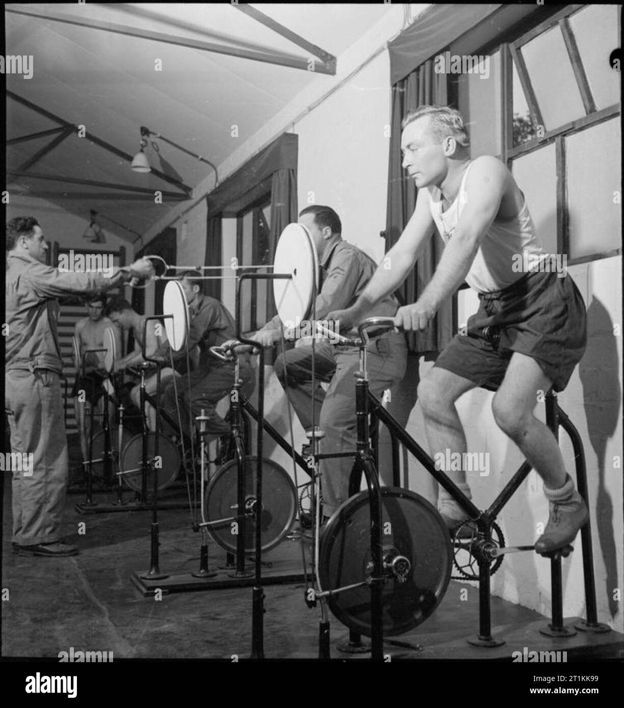 First US Army Rehabilitation Centre- Recuperation and Training at 8th Convalescent Hospital, Stoneleigh Park, Kenilworth, Warwickshire, UK, 1943 Pfc Verble Billings (of Route 1, Covington, Tennessee) rides an exercise bicycle in the remedial gymnasium at 8th Convalescent Hospital at Stoneleigh Park. Billings was with the field artillery and was wounded by shrapnel in the back of the knee near Tunis. Before the war, Billings worked on his father's farm in Covington. Stock Photo
