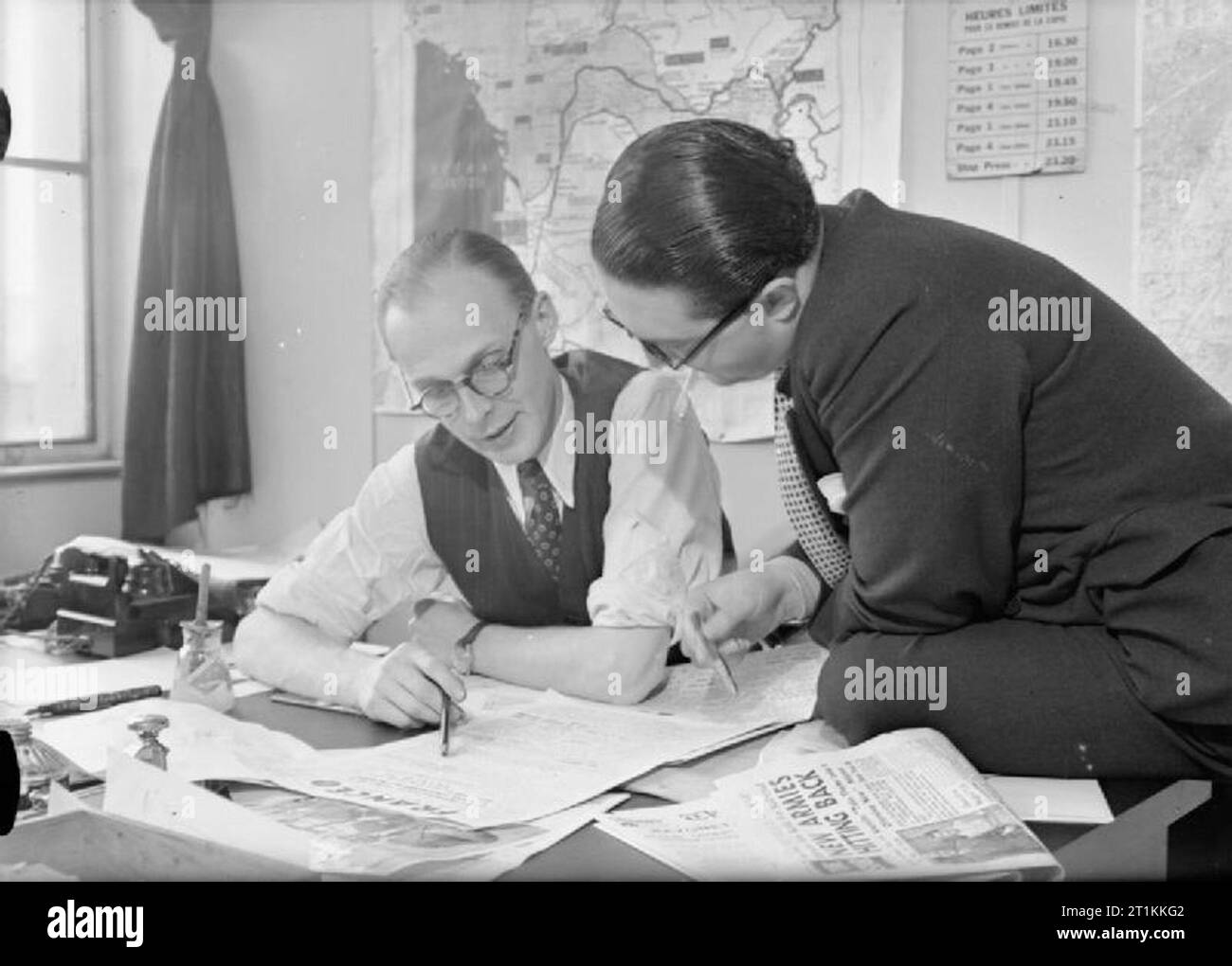 French Newspaper in Britain- Wartime News and Propaganda, England, 1942 Andre Rabsche (left) and Charles Gombault, General Secretaries of the newspaper 'France' discuss the layout of the next edition at their office in London. Stock Photo